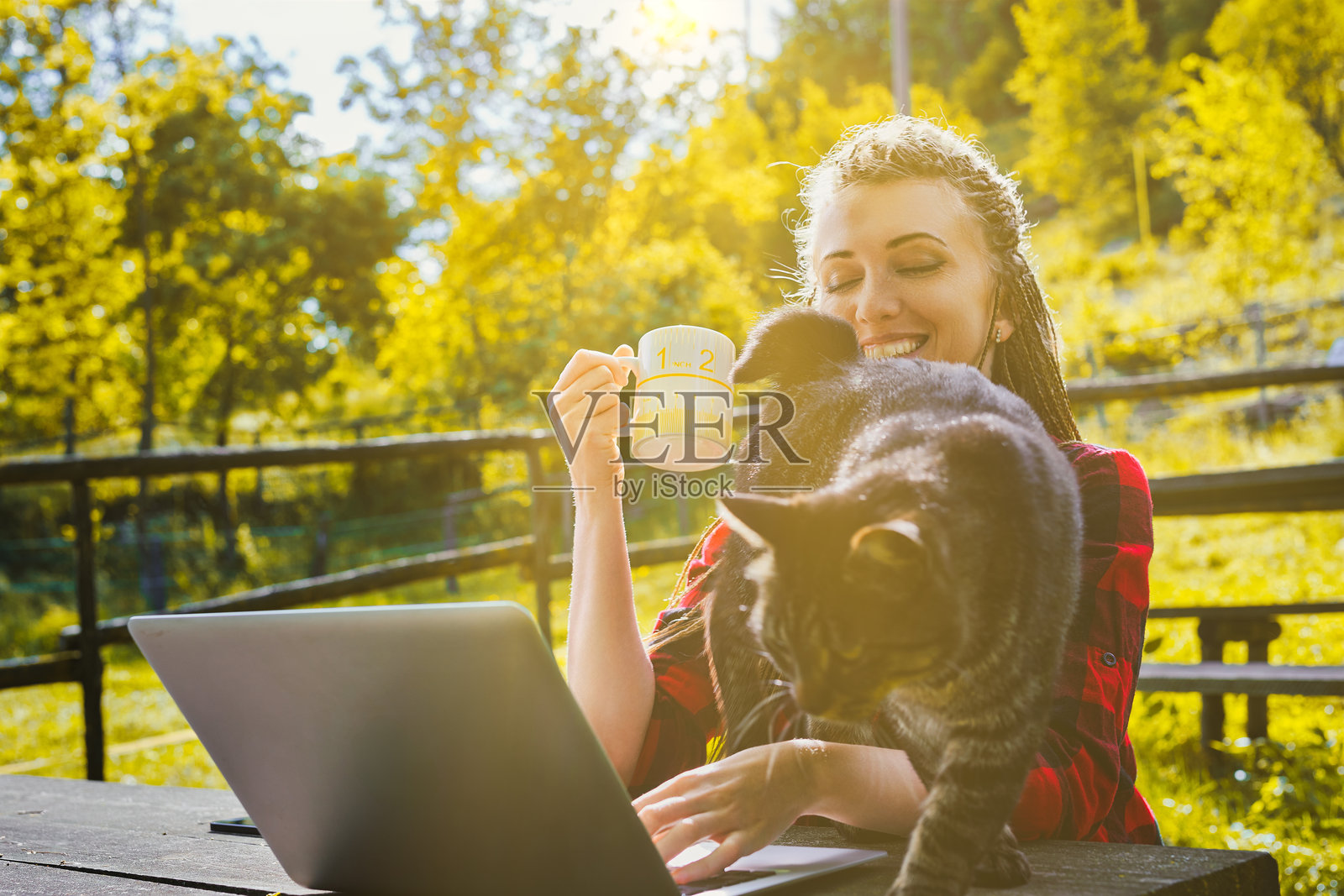 一位自由职业女性正在使用笔记本电脑喝咖啡照片摄影图片