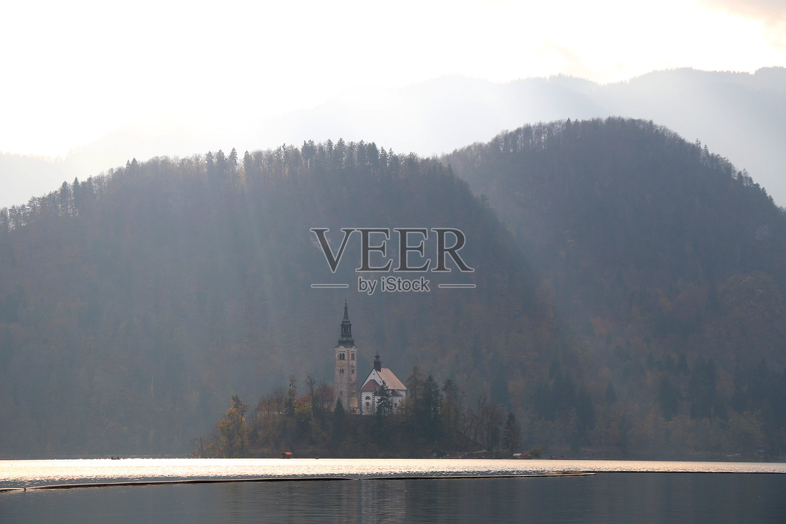 斯洛文尼亚布莱德湖上的教堂与秋季树叶照片摄影图片