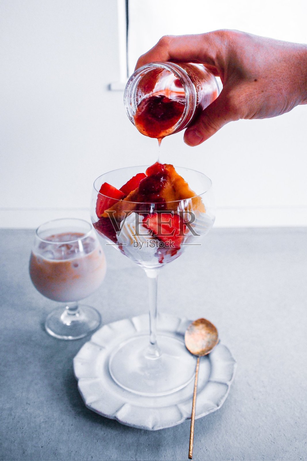 新鲜水果和酸奶制作的草莓优格早餐,摆放在乡村风格的白色桌子上。选择性对焦,背景和前景模糊。照片摄影图片