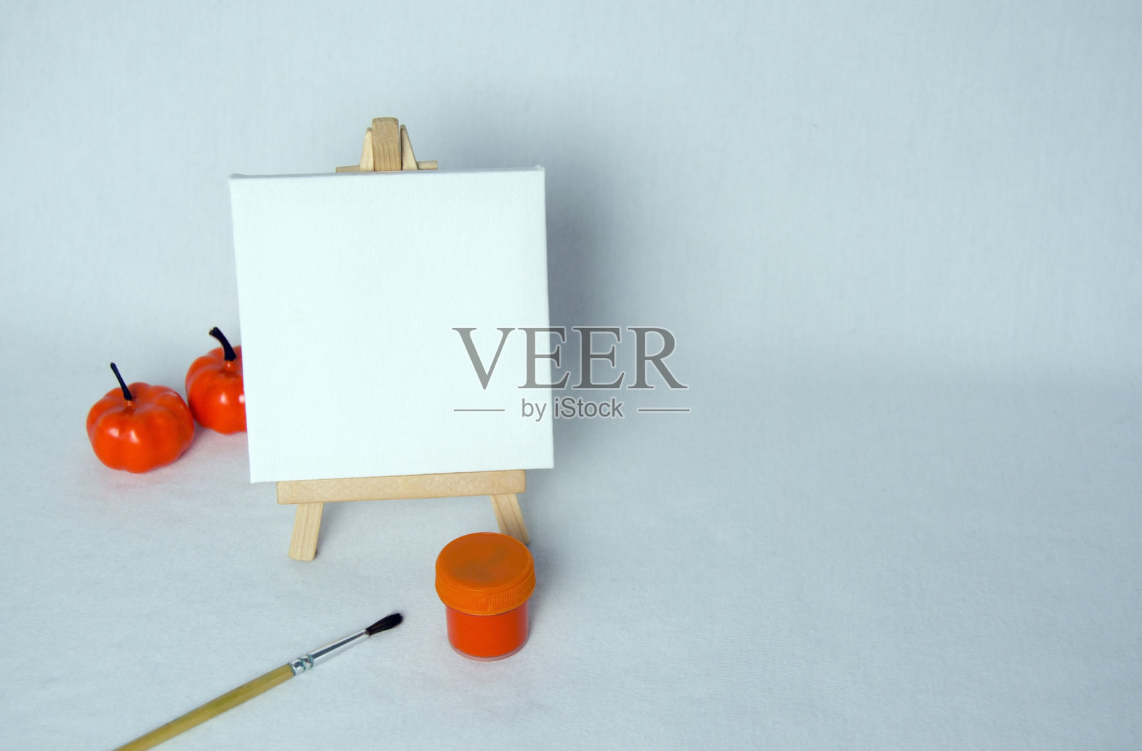 迷你画架上放着白色空白画布。艺术概念。万圣节概念。秋季概念。白色背景。照片摄影图片