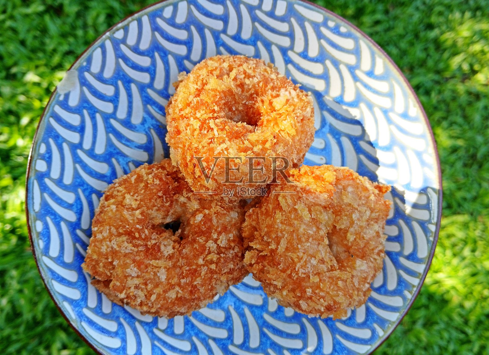 碗中的炸虾饼 - 绿色背景。照片摄影图片