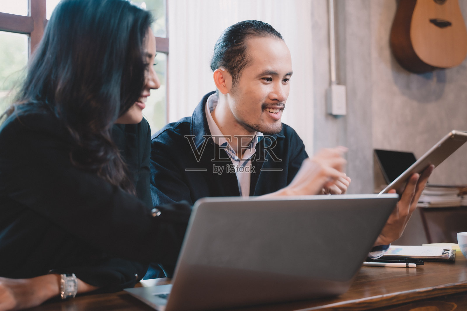 两位商务人士在项目会议中愉快交流。两位合作伙伴正在讨论商业计划与技术。照片摄影图片