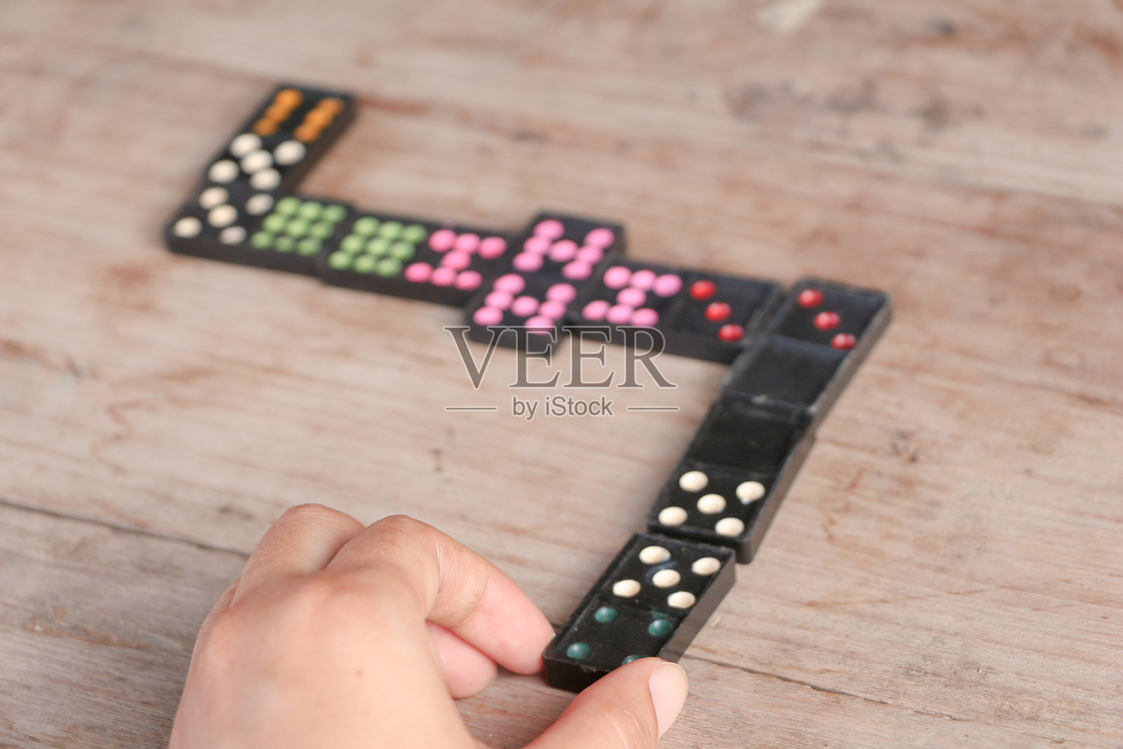 一个人正在桌子上摆放多米诺骨牌的手部特写照片摄影图片