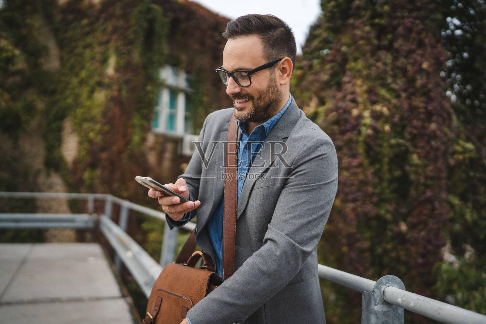 成年男性商人在露台上使用手机照片摄影图片