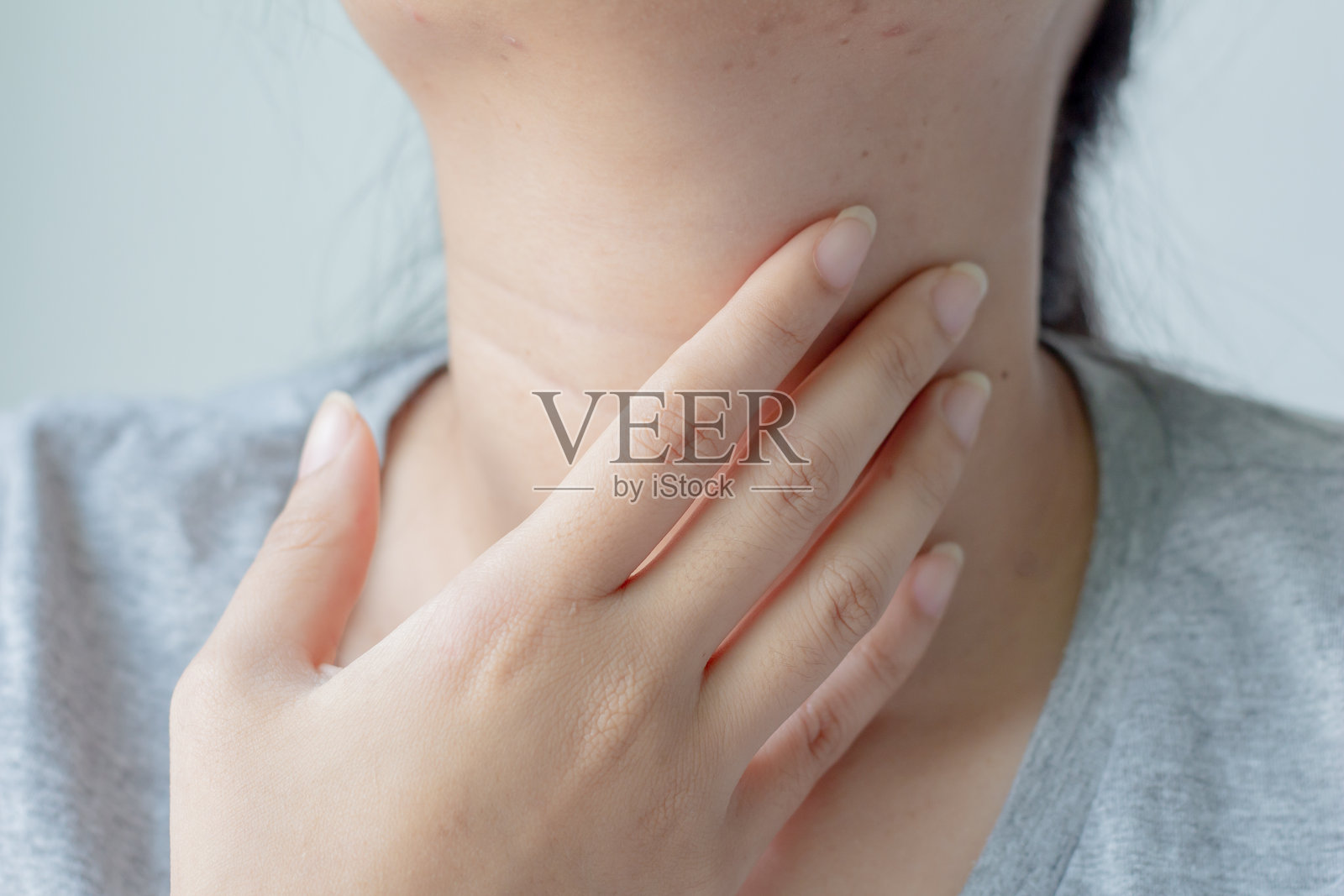 白色背景下,女性中部因颈部疼痛而苦恼照片摄影图片