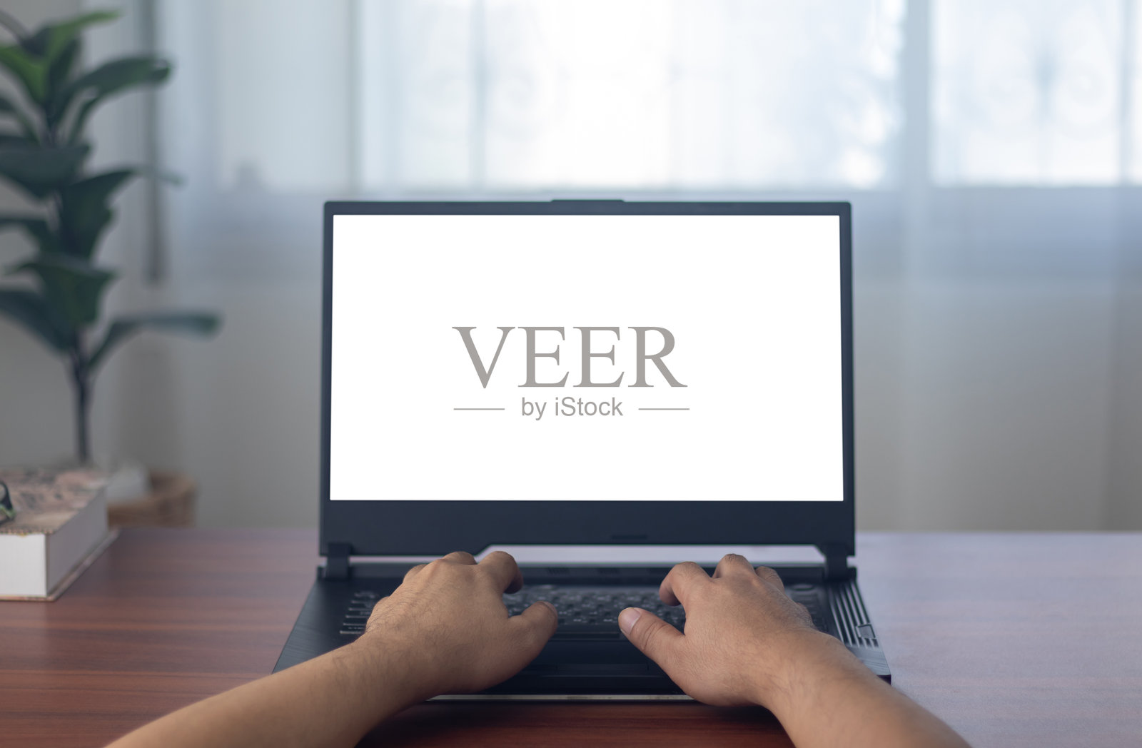 男人的手在白色背景前使用笔记本电脑。照片摄影图片