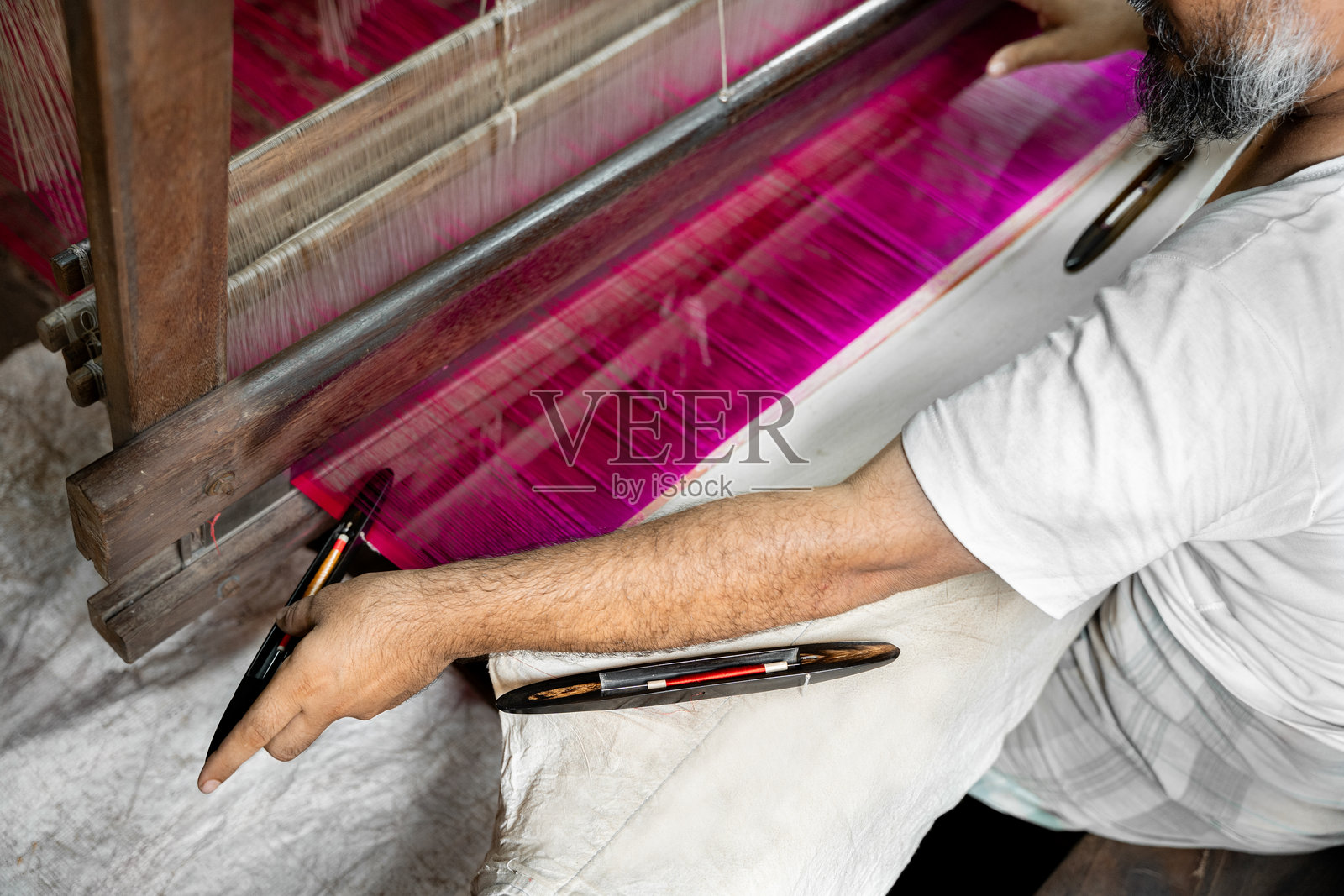 一位成熟男性在传统织机上工作的手照片摄影图片