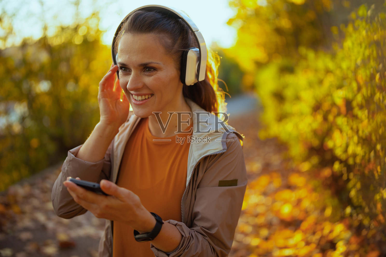 快乐的40岁女性穿着健身服在公园里锻炼照片摄影图片