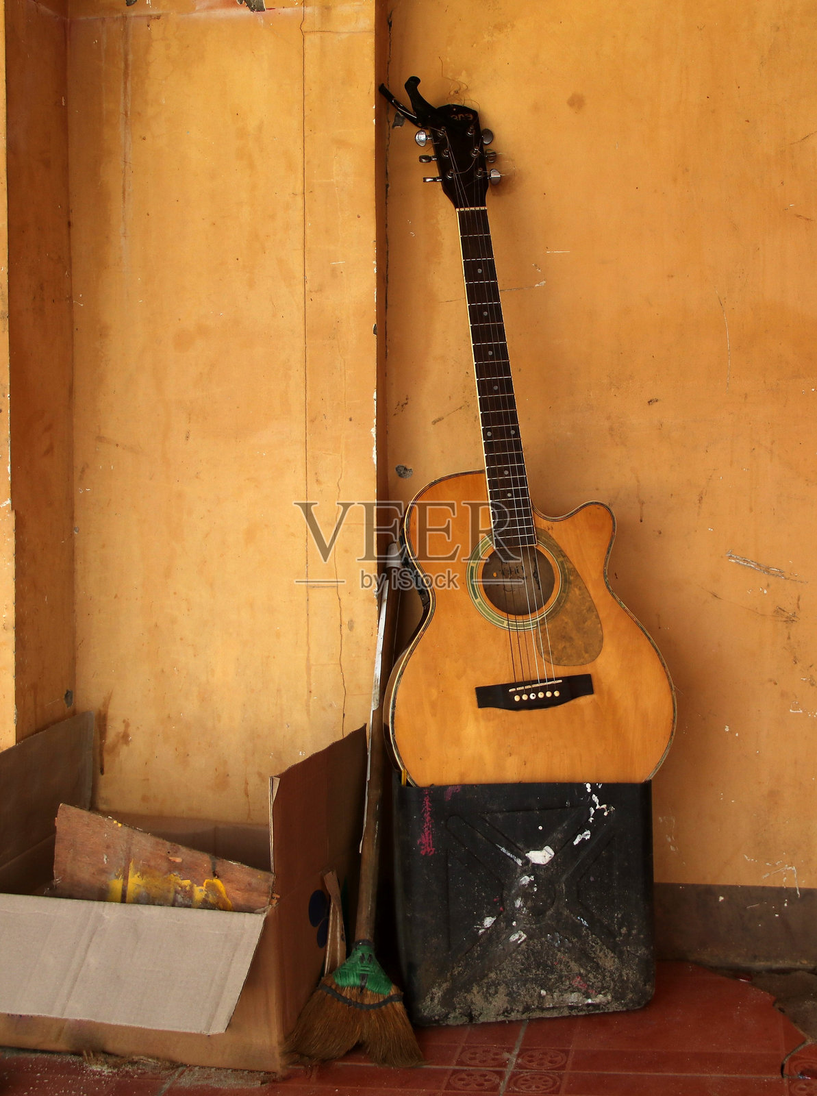 被遗忘的旧木吉他与其他旧物品一起。照片摄影图片