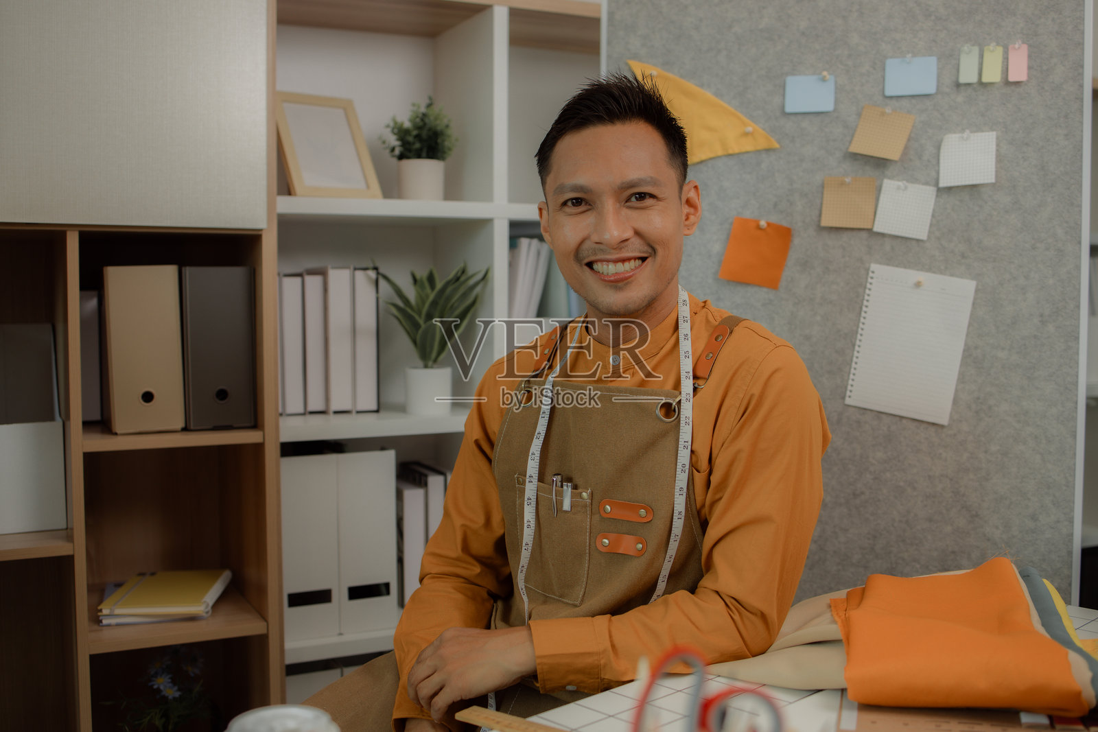 一位时装设计师在他的工作室中展示各种姿势,一位裁缝在时尚房间中摆姿势拍照,表达不同的情感,时尚、服装、流行、纺织品。照片摄影图片