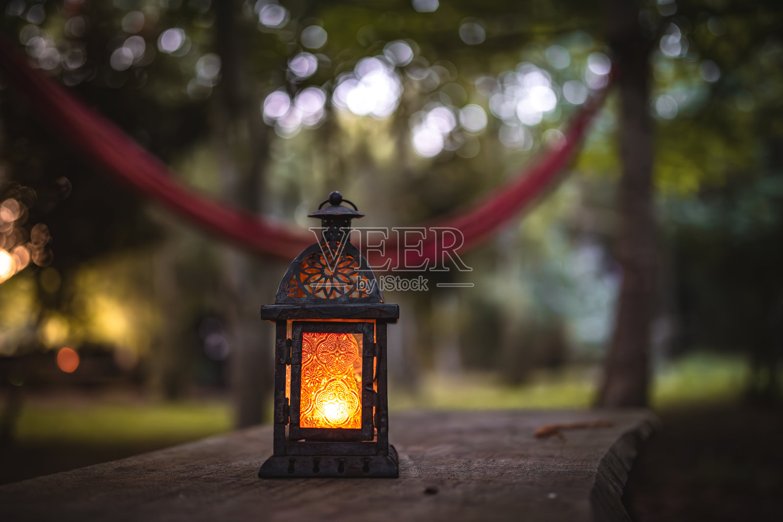 露营地木桌上的油灯和蜡烛灯笼。照片摄影图片