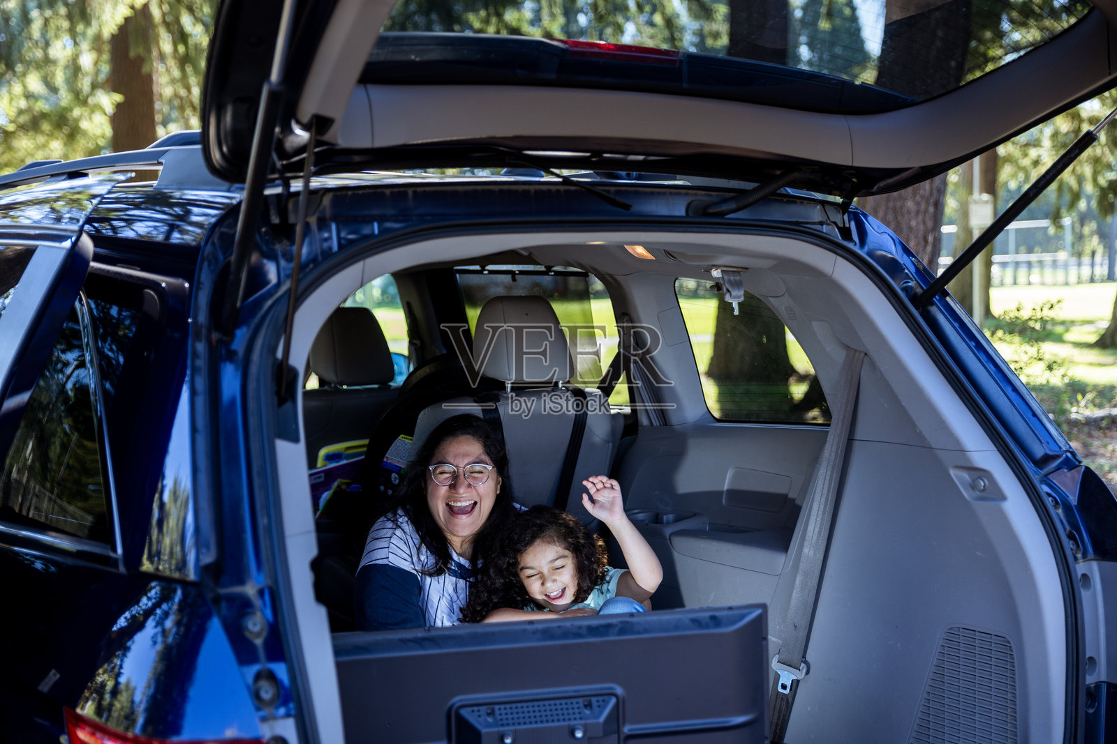 一家人坐在户外的SUV后面观看小电视屏幕照片摄影图片