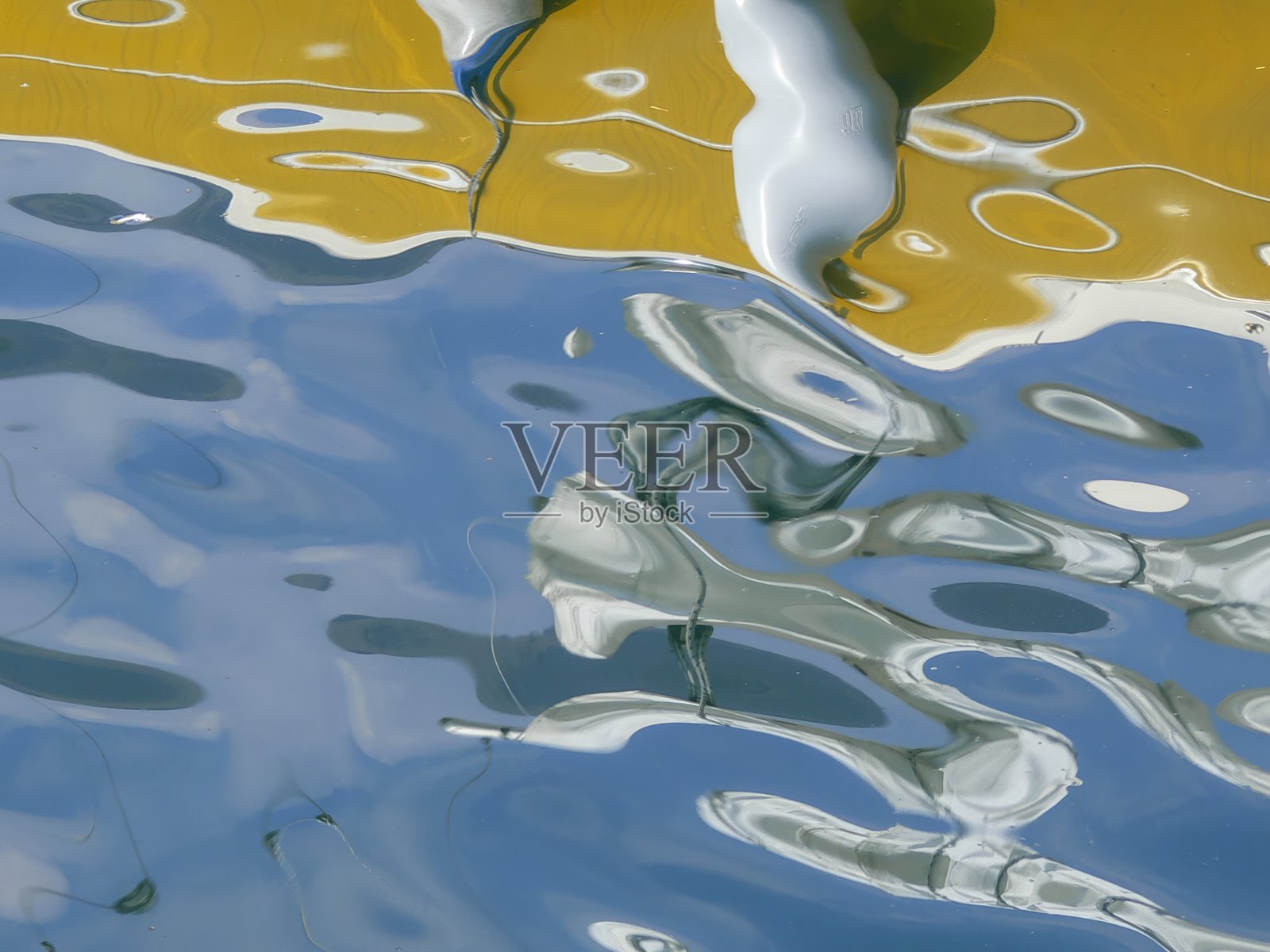 水面上的倒影形成了一幅抽象的图像。照片摄影图片