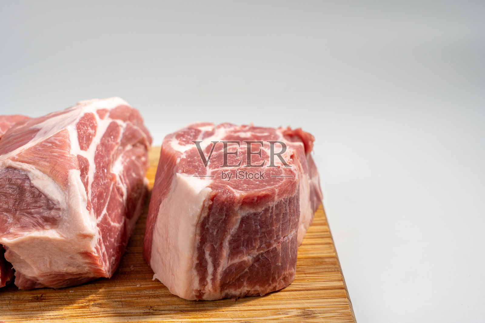 一块肉被切成片,放在木质切菜板上。照片摄影图片