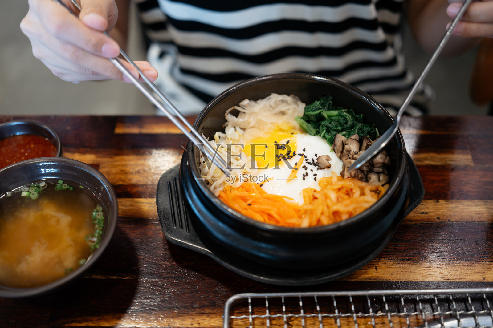 女人在韩国餐厅吃拌饭照片摄影图片