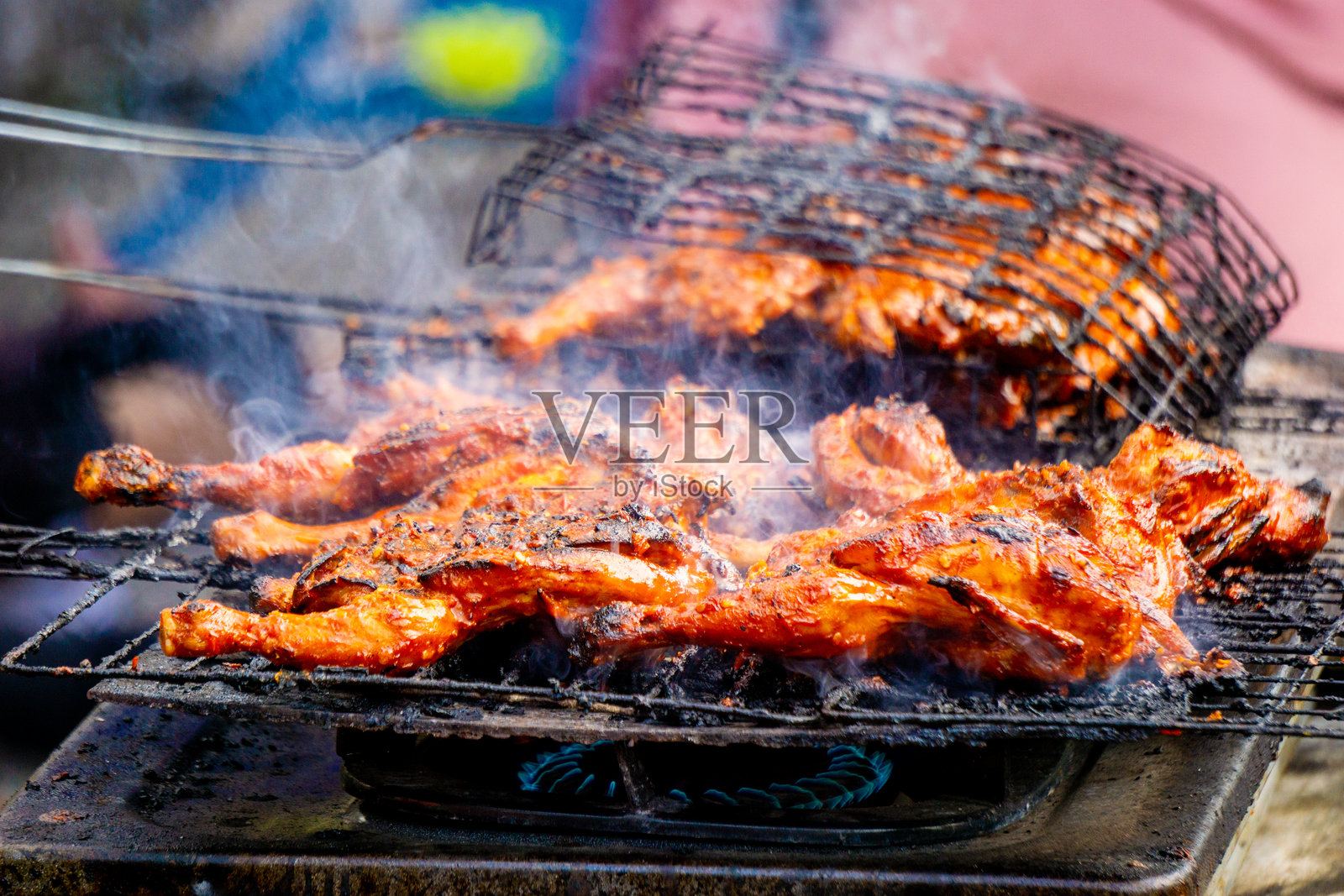 卖家用酱油、香草和来自印度尼西亚的香料烤制的鸡肉。印度尼西亚人称这种食物为ayam bakar。照片摄影图片