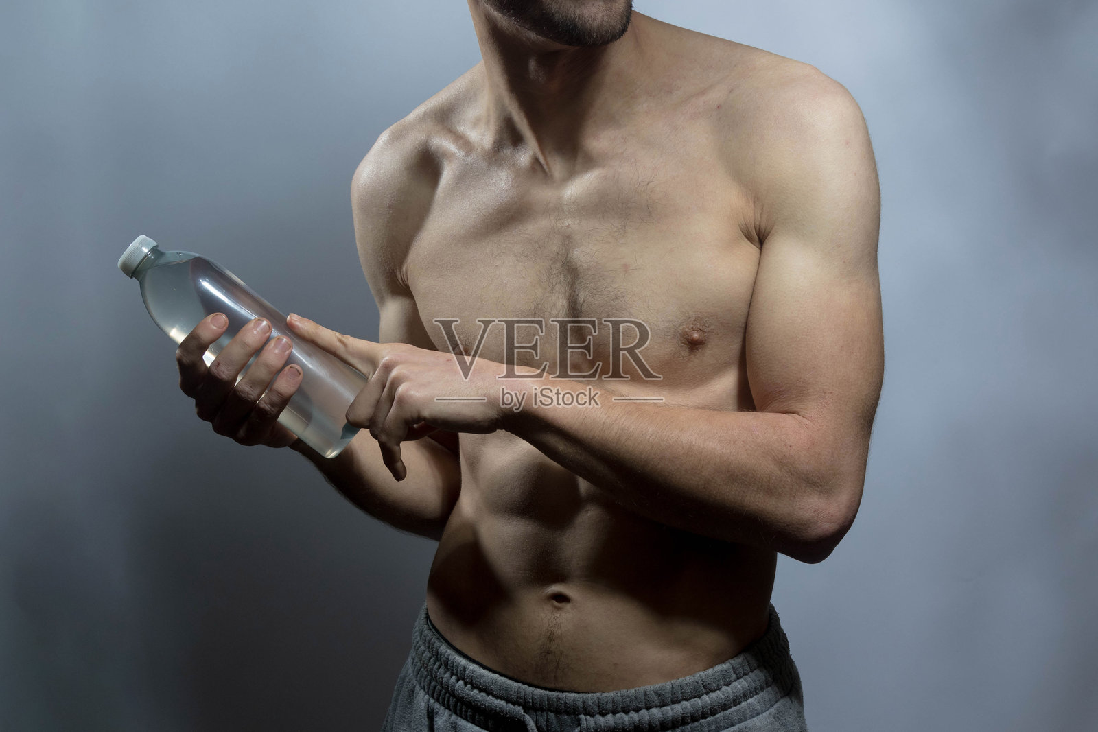 一位年轻的强壮男士,赤裸上身照片摄影图片