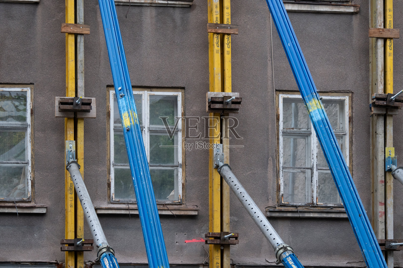 在建筑工地上,房屋外立面由柱子支撑。照片摄影图片