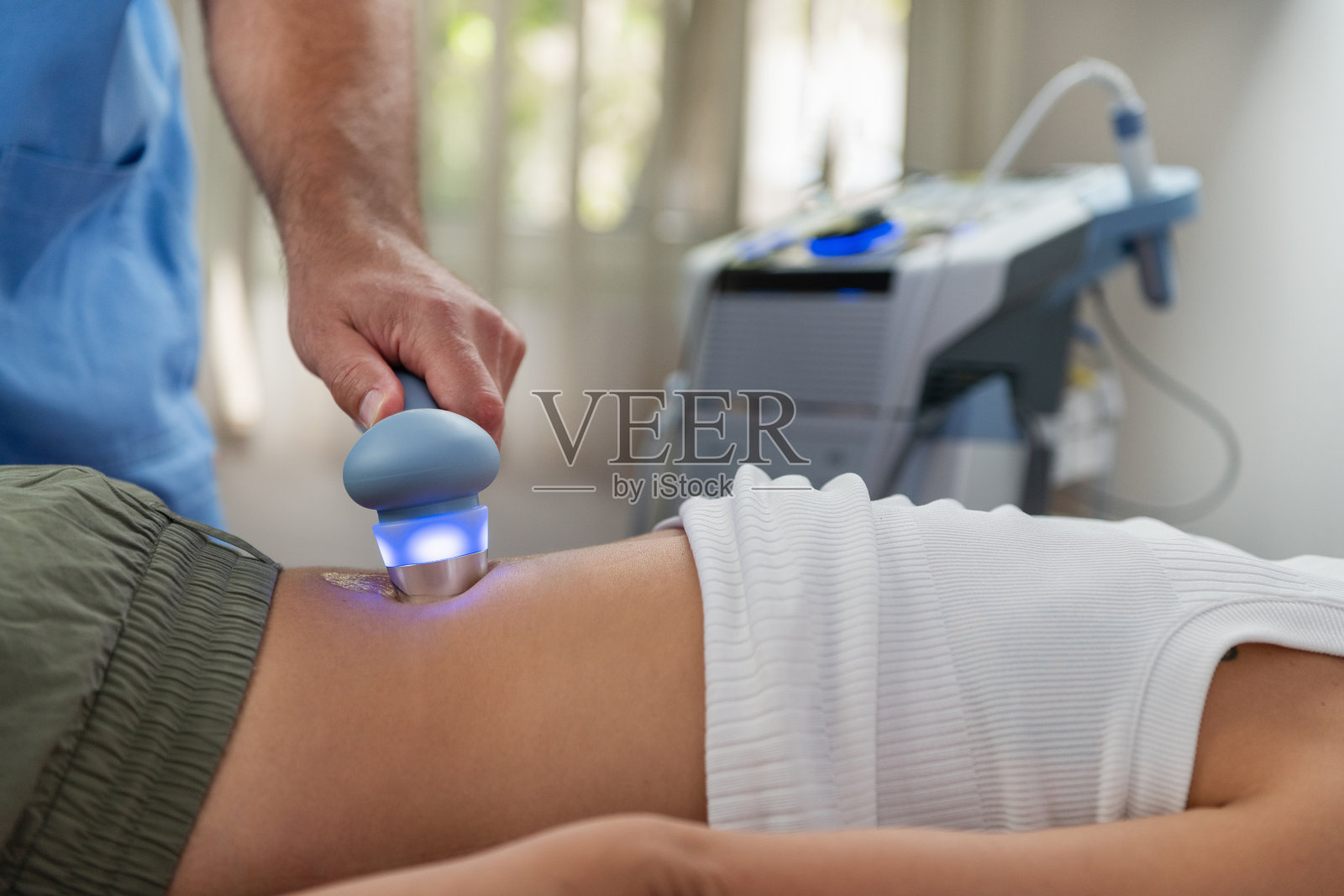 物理治疗师在专业临床环境中对患者的下背部进行超声波治疗,以缓解疼痛并促进愈合,增强活动能力和恢复。照片摄影图片