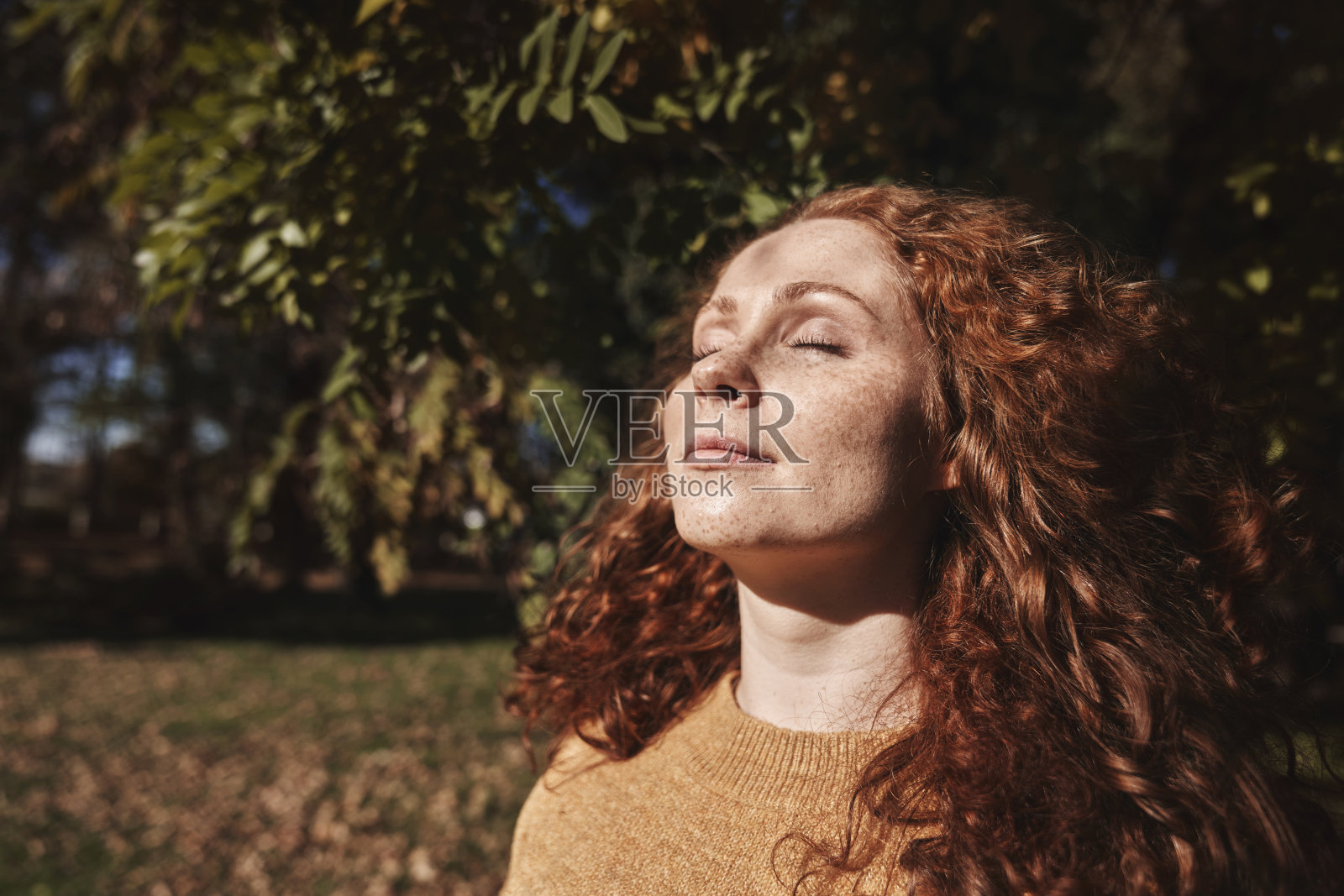 女人闭上眼睛享受秋日阳光照片摄影图片