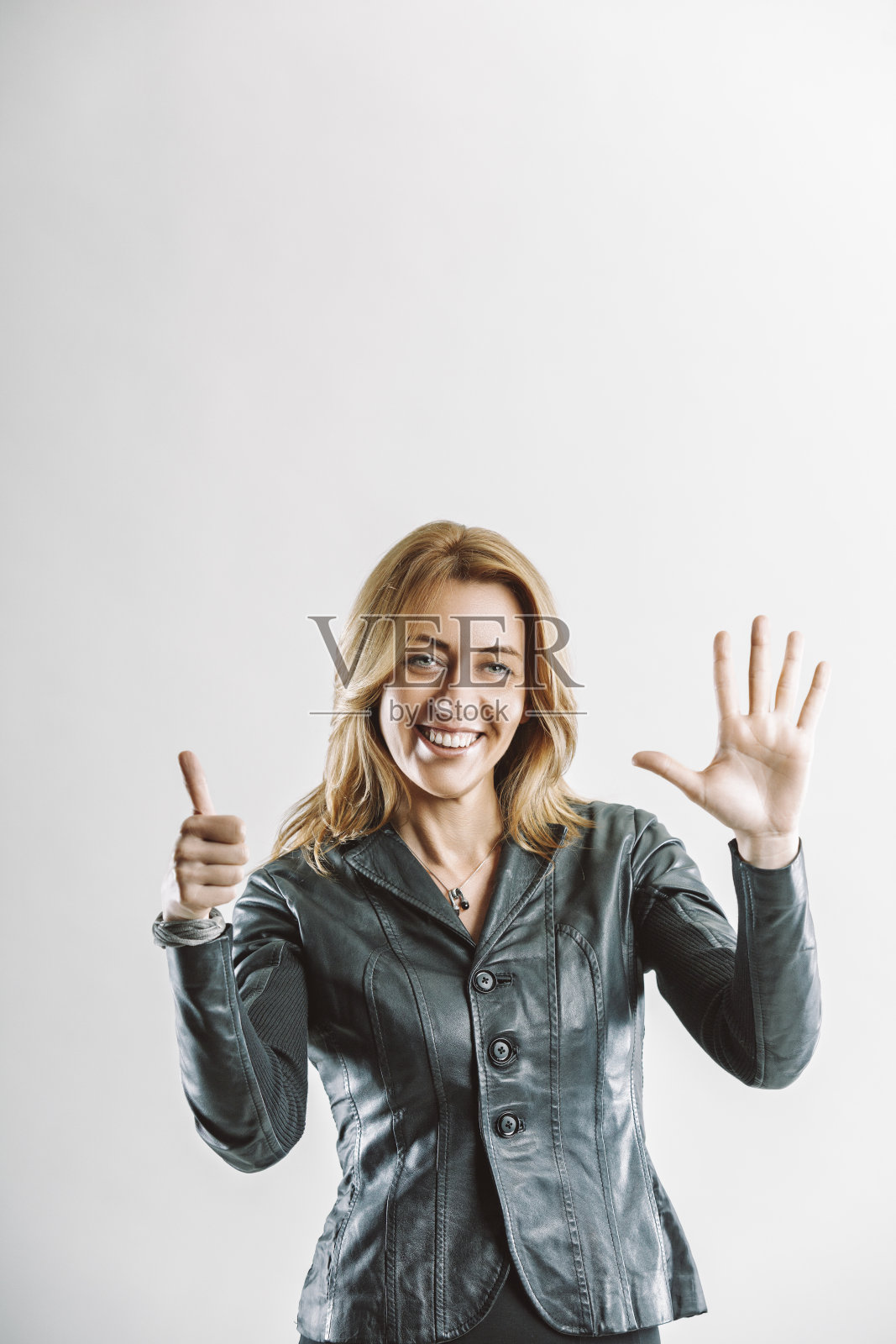 热情的女商人用手势表示六并竖起大拇指照片摄影图片