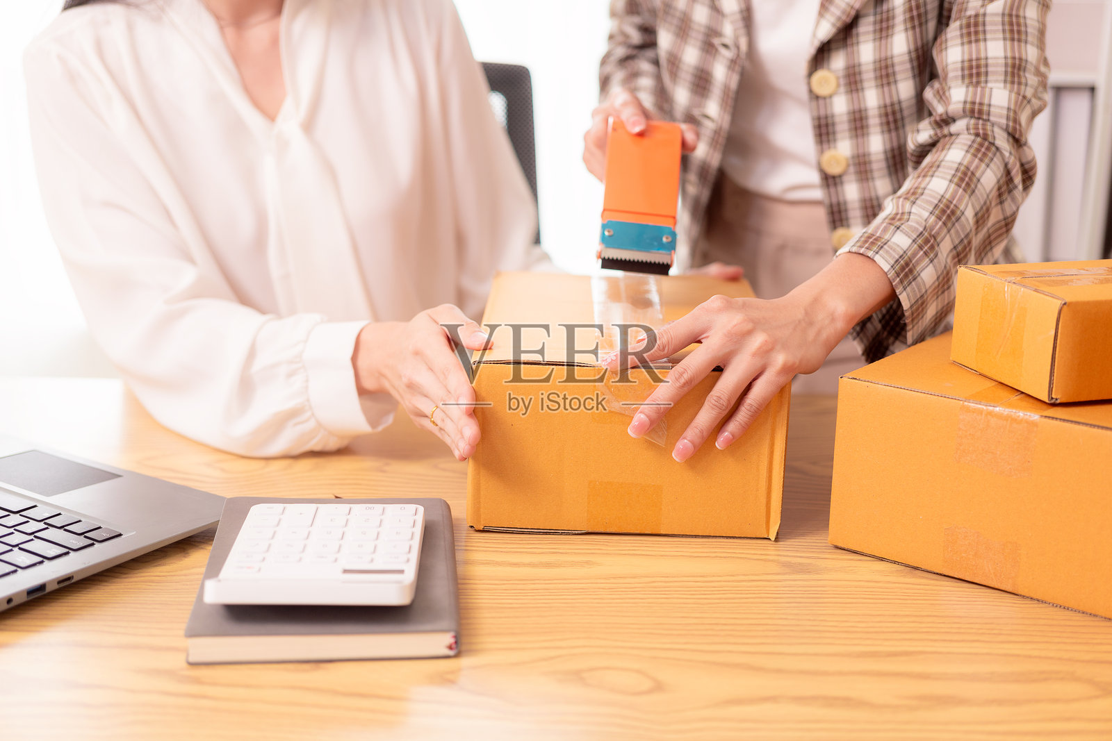 小型企业创业,SME老板,亚洲女性查看在线订单,在家销售产品,处理箱子和笔记本电脑,自由职业者照片摄影图片