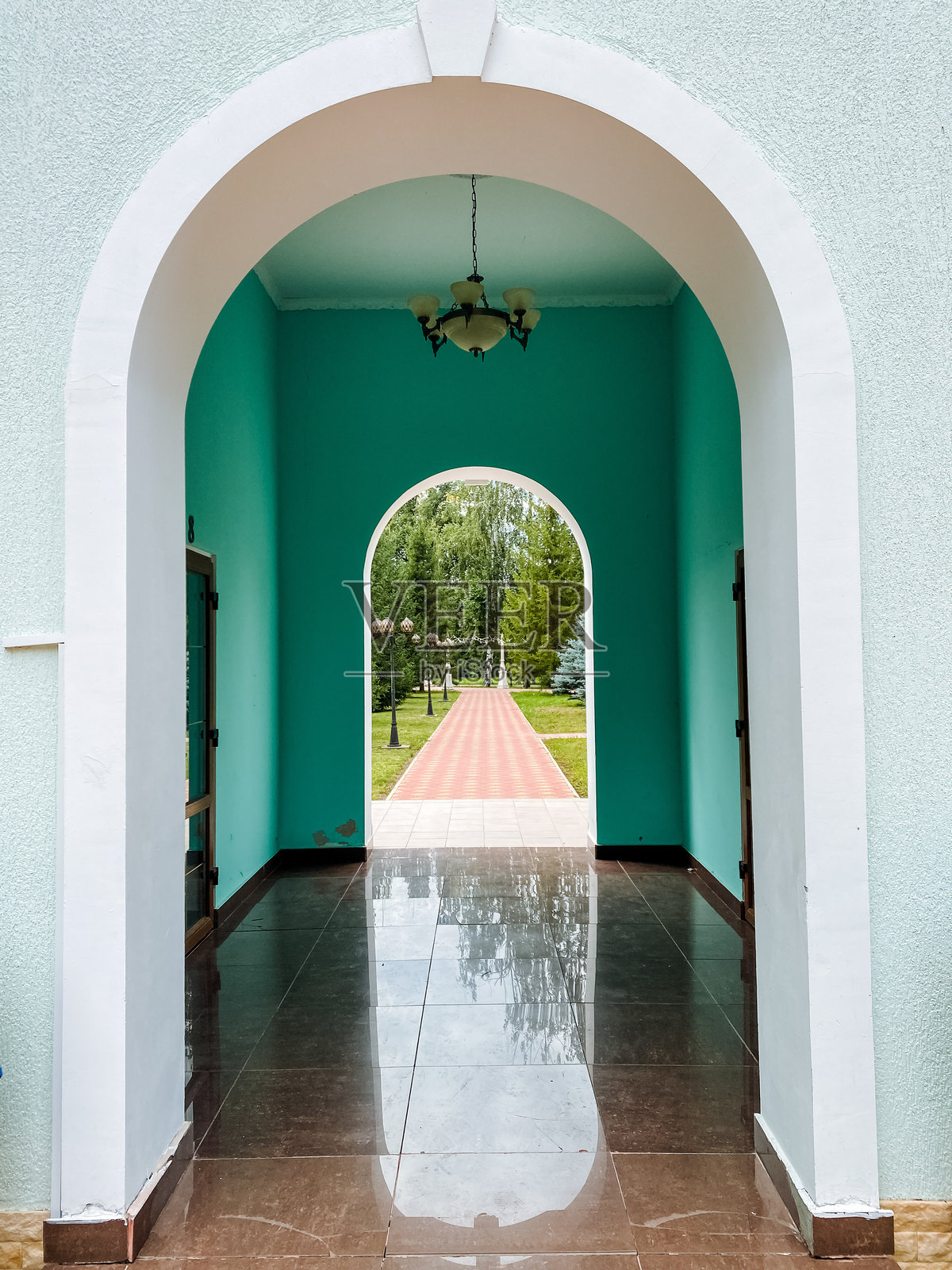 一个优雅设计的拱门将华丽的走廊与宁静的公园连接起来,创造出无缝的过渡,提升了空间的整体氛围和体验。照片摄影图片