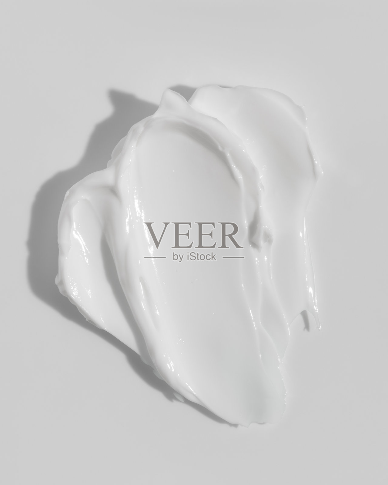 白色美容霜在白色背景上的涂抹痕迹。化妆品护肤产品质地。面霜、身体乳液的涂抹样本。照片摄影图片