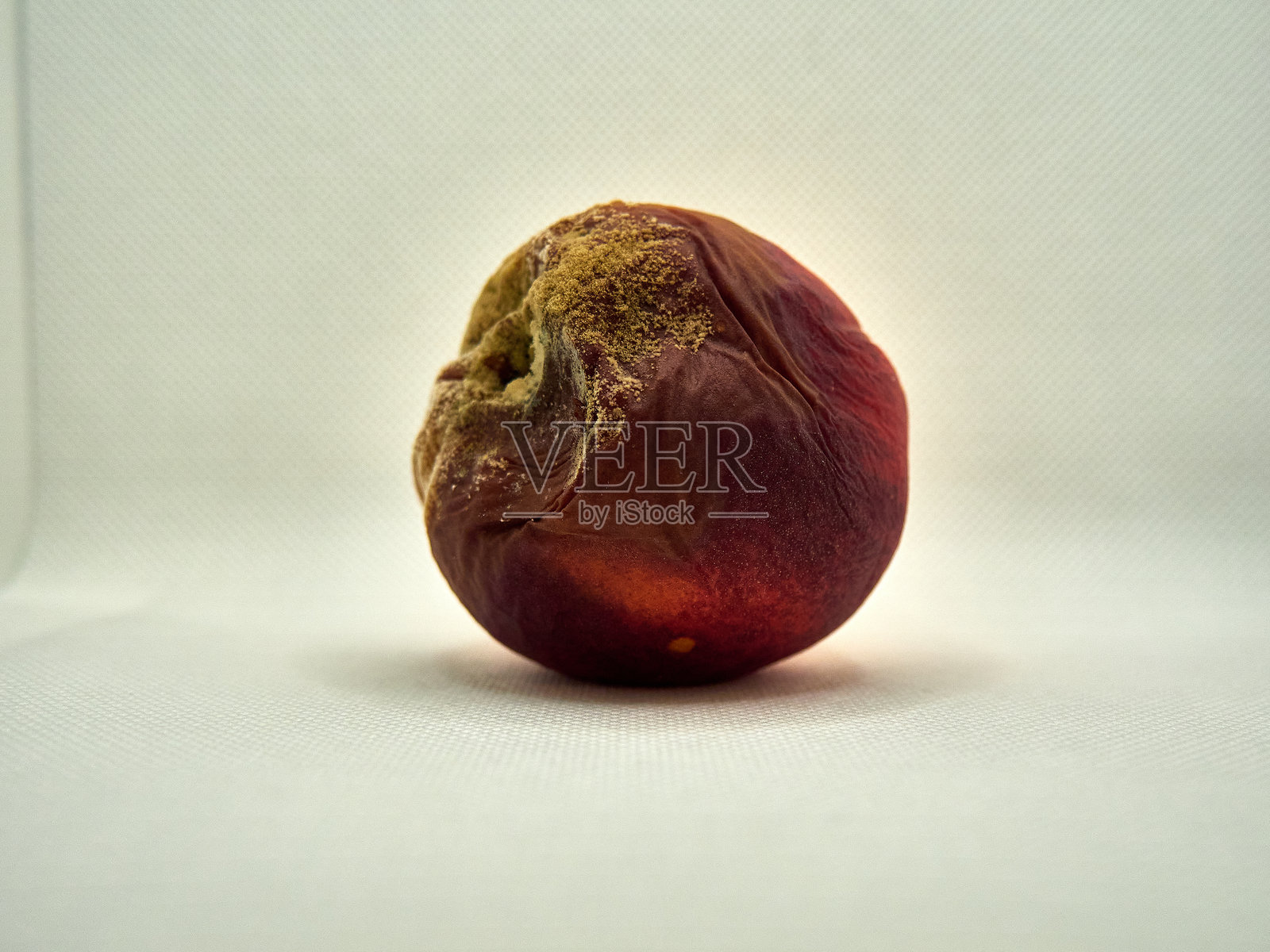 白色背景上的霉烂桃子照片摄影图片