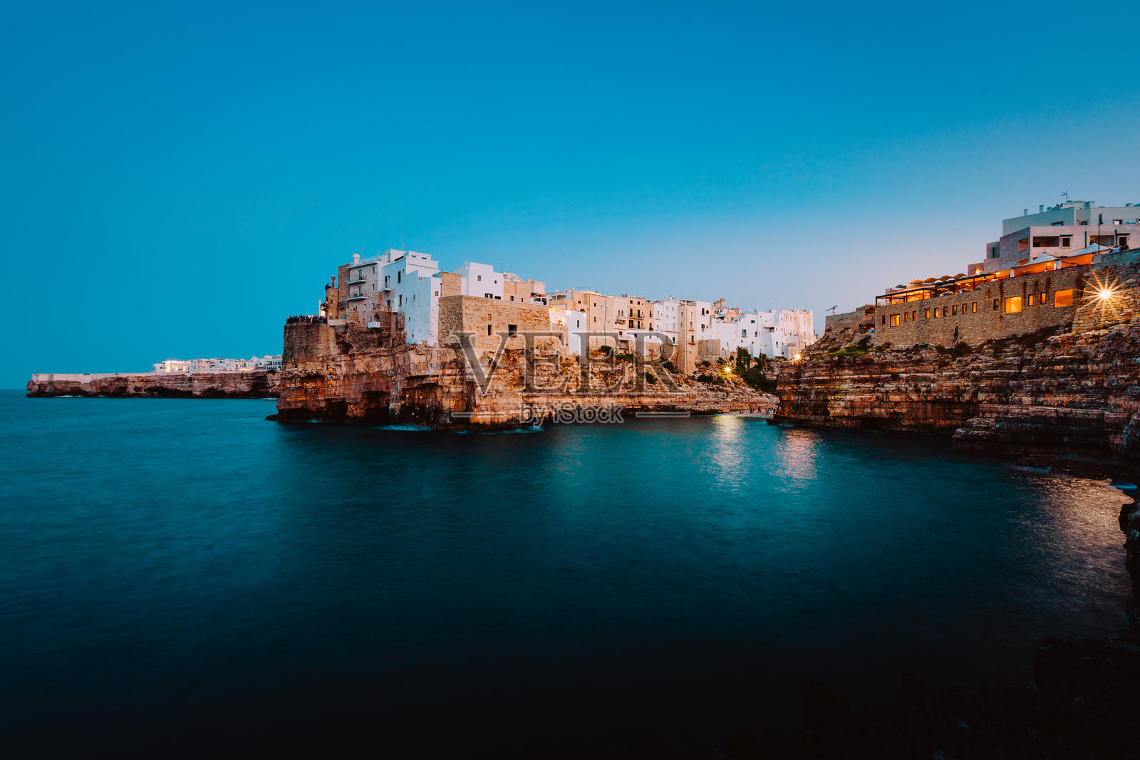 日落时分的波利尼亚诺·阿·马雷,蓝色时刻,从村庄前的观景点俯瞰。照片摄影图片