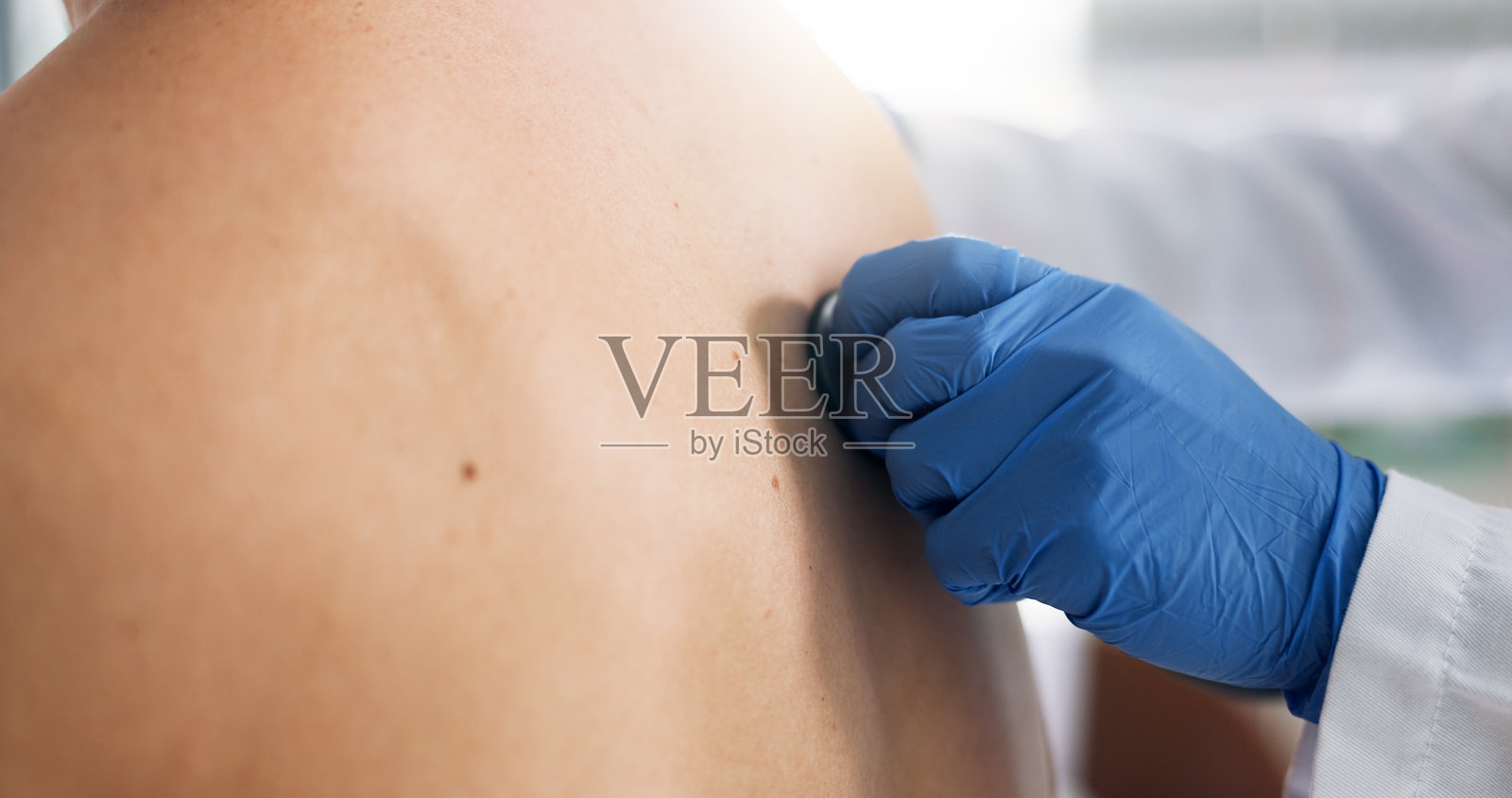 医生的手和听诊器放在病人背上进行呼吸或呼吸系统检查。哮喘,医疗专业人员在咨询或医疗过程中听取肺部声音以进行医学测试。照片摄影图片