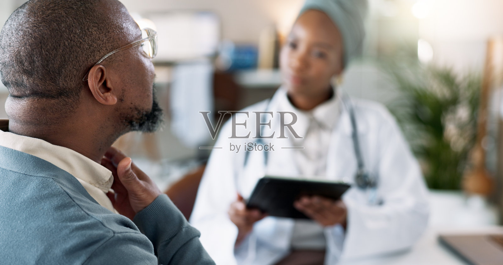 喉咙痛,黑人男性在医院与医生进行单核细胞增多症的医疗评估。流感,非洲男性患者与医疗工作者在诊所进行健康检查的对话。照片摄影图片