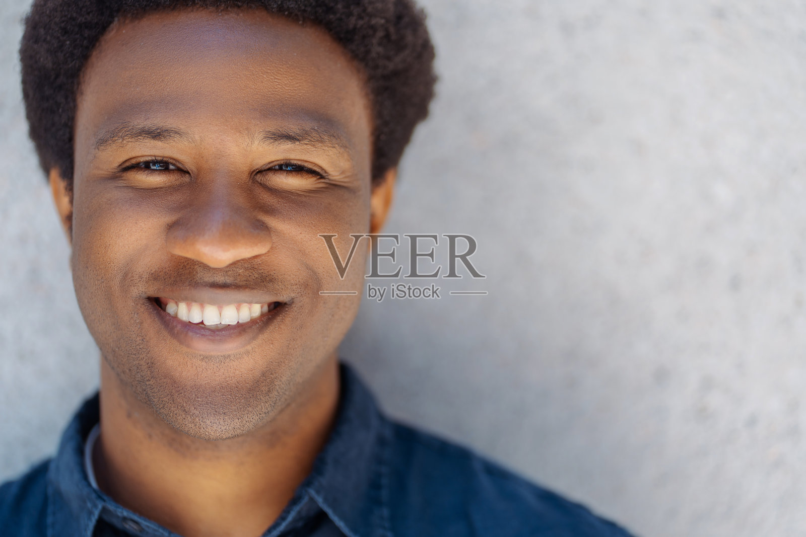 年轻帅气的男人在灰色背景前微笑照片摄影图片