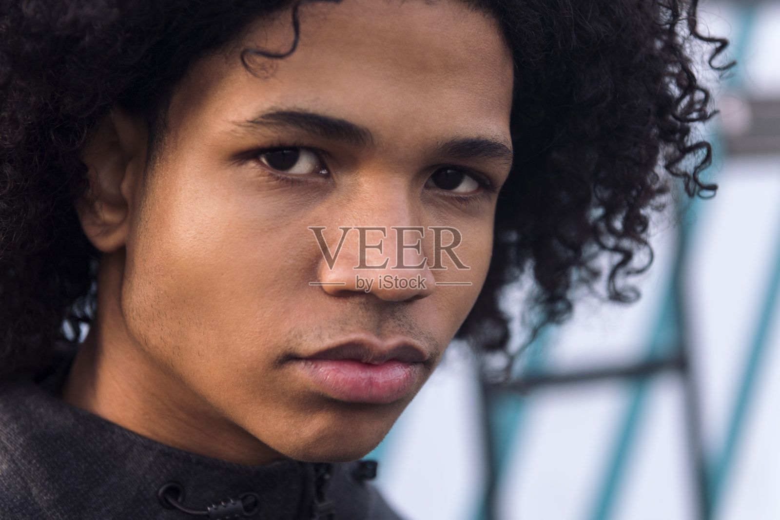 卷发的黑人男青少年正在看着镜头照片摄影图片