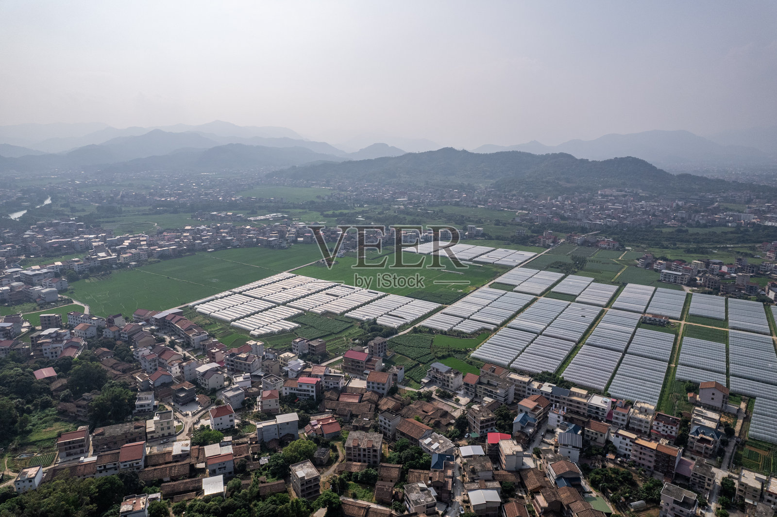 村庄和现代农业温室的鸟瞰图照片摄影图片