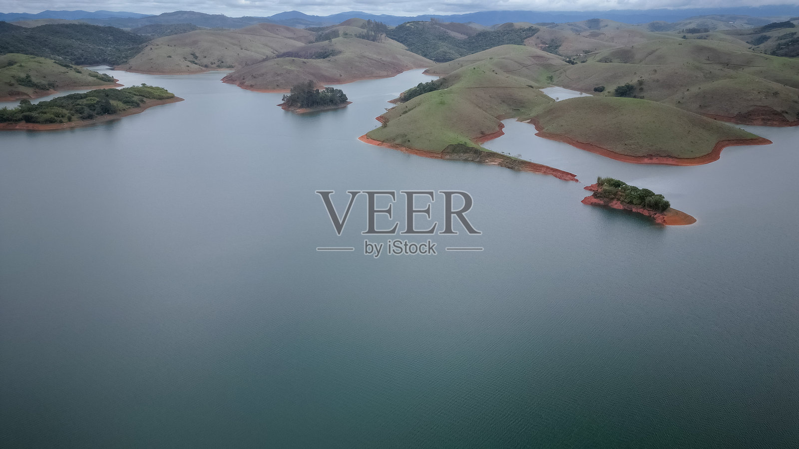 从上方用无人机拍摄的完整水坝,水位较低,背景是自然风光。照片摄影图片