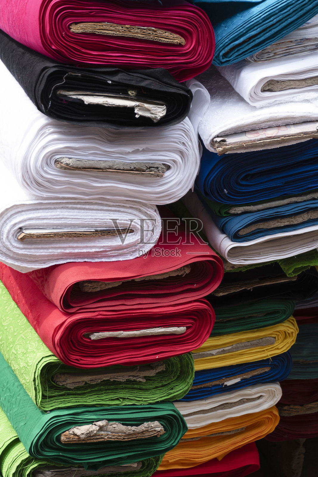 街市上堆叠的五彩缤纷的布料卷特写照片摄影图片