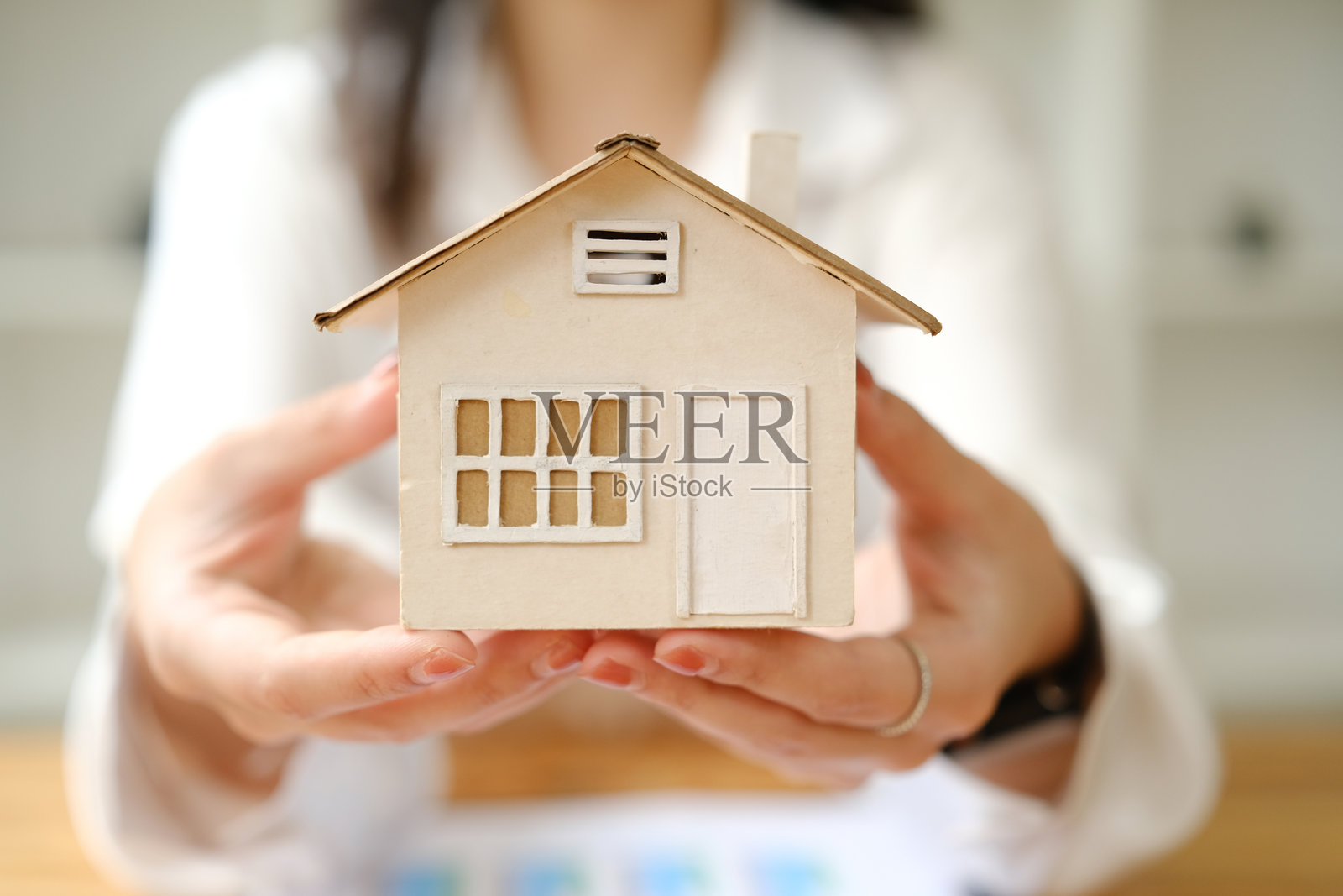 一名妇女正在展示她计划出售概念人工智能生成的房子模型照片摄影图片