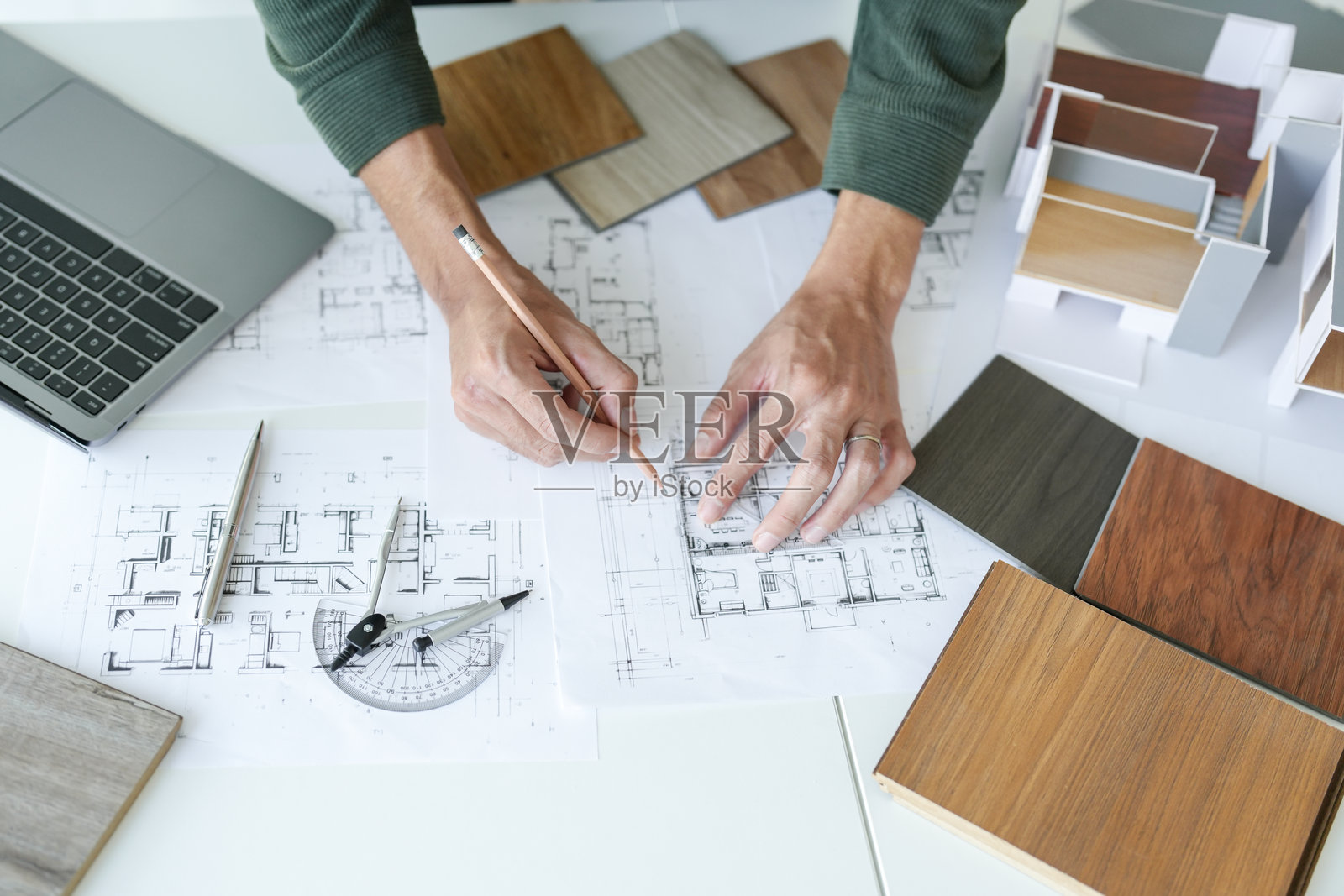 亚洲男性建筑室内设计师的创意项目计划,选择室内材料,蓝图上的室内绘图。照片摄影图片