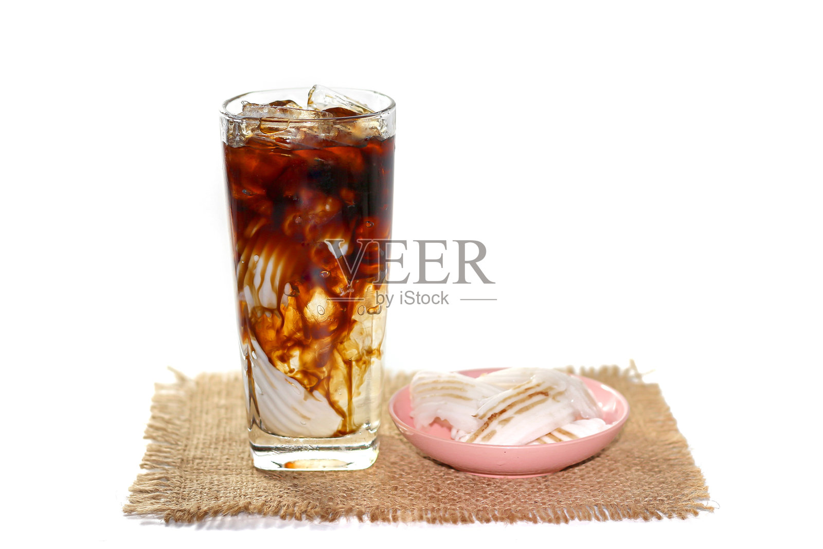 美式冰咖啡配椰子片,放在麻袋上,白色背景,孤立概念。照片摄影图片