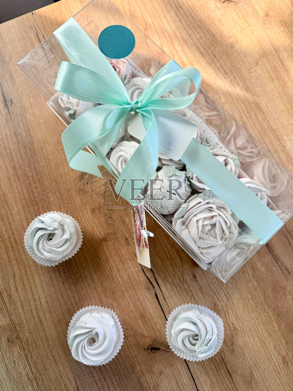 透明盖子礼盒中的棉花糖花朵。卡片上用俄语写着“无尽的幸福”。照片摄影图片