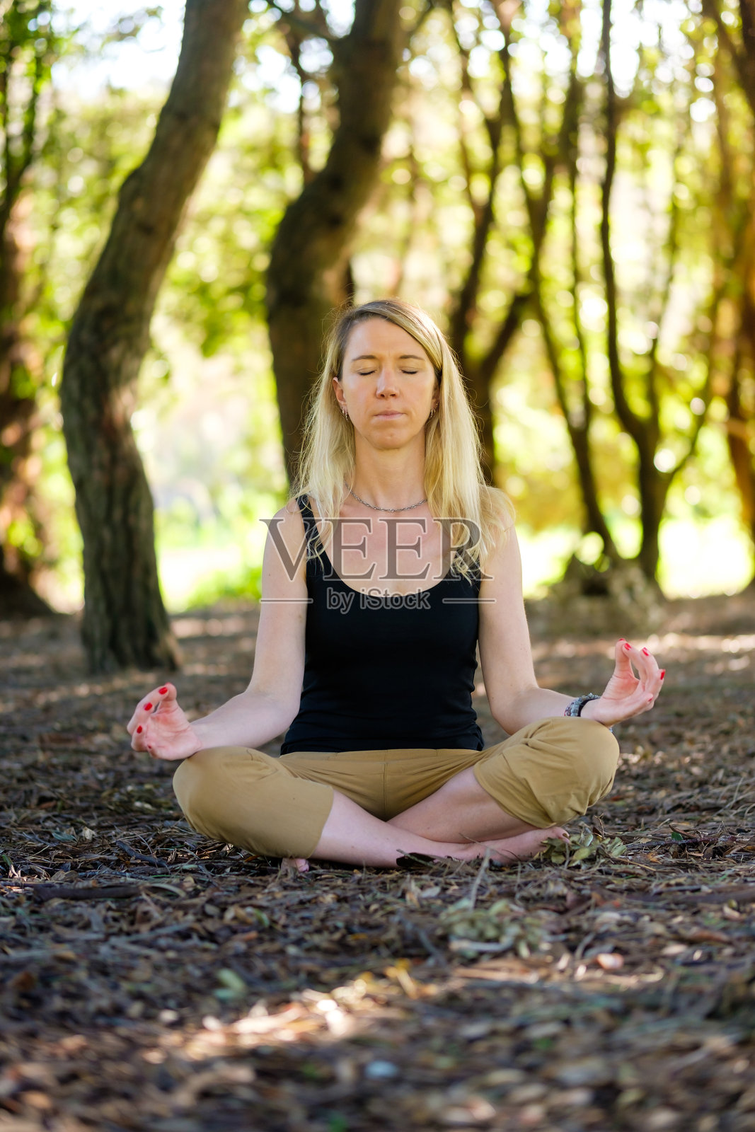 女人坐在大自然中冥想,进行接地/大地疗法。照片摄影图片