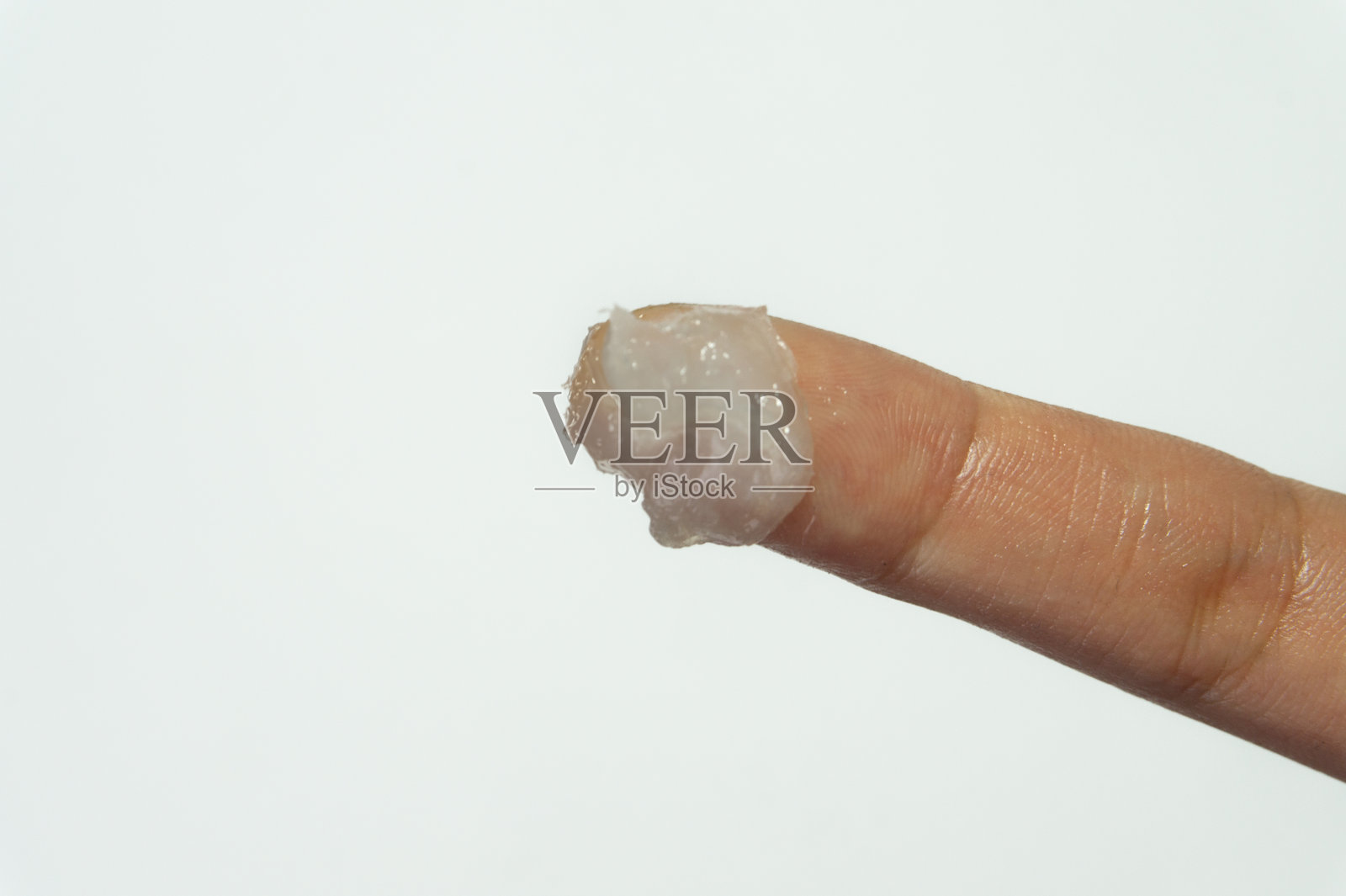 女性手指上沾有化妆用石油膏的特写。留有文字空间。照片摄影图片