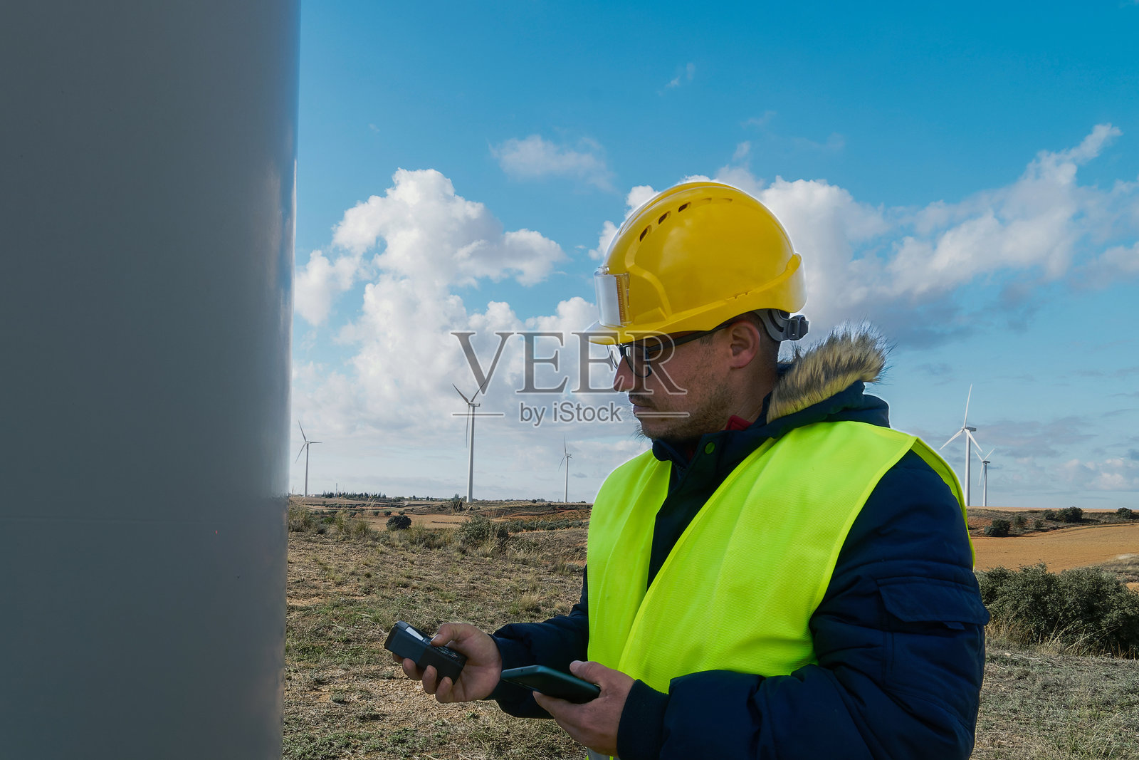 工程师使用数字设备检查正在运行的风力涡轮机照片摄影图片