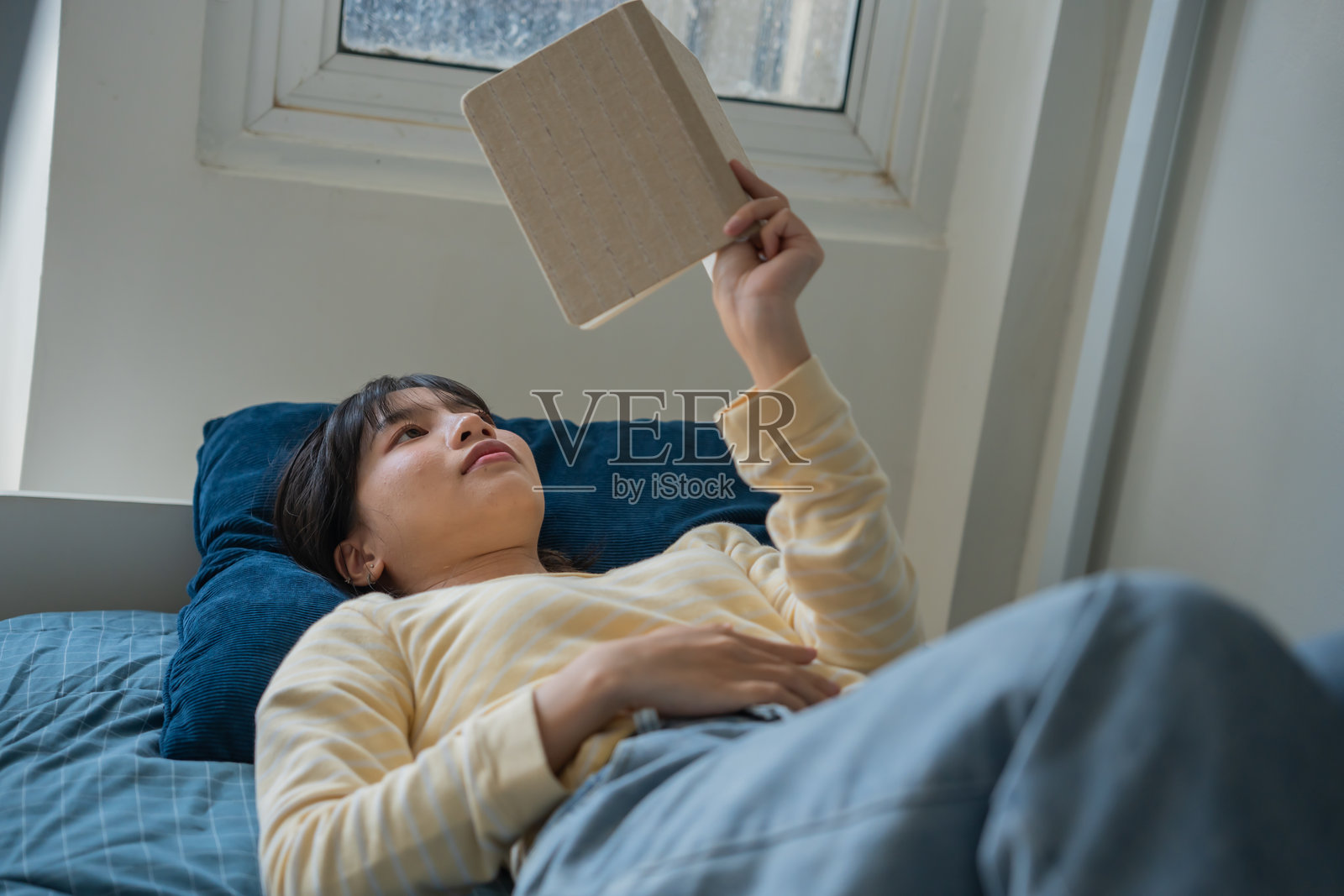 亚洲女性学生在宿舍里阅读书籍,大学生在大学宿舍做作业照片摄影图片