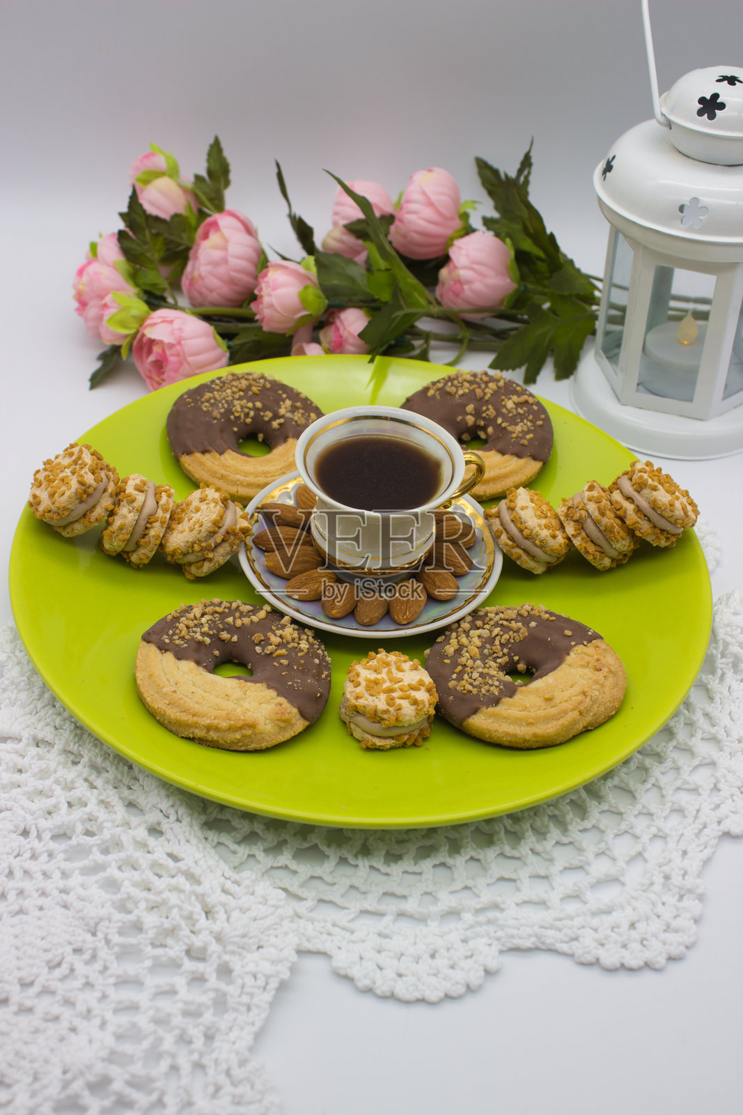 绿色盘子上的咖啡、饼干和杏仁照片摄影图片