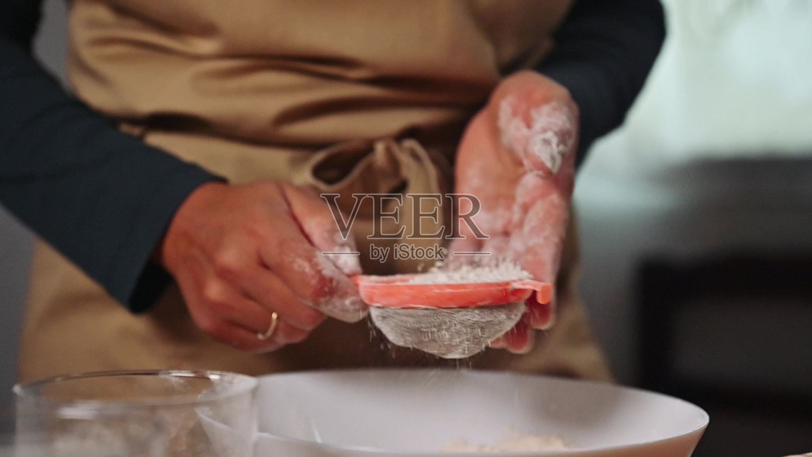 家庭烘焙师在温馨的乡村风格厨房中将面粉筛入碗中,准备美味的自制蛋糕。照片摄影图片