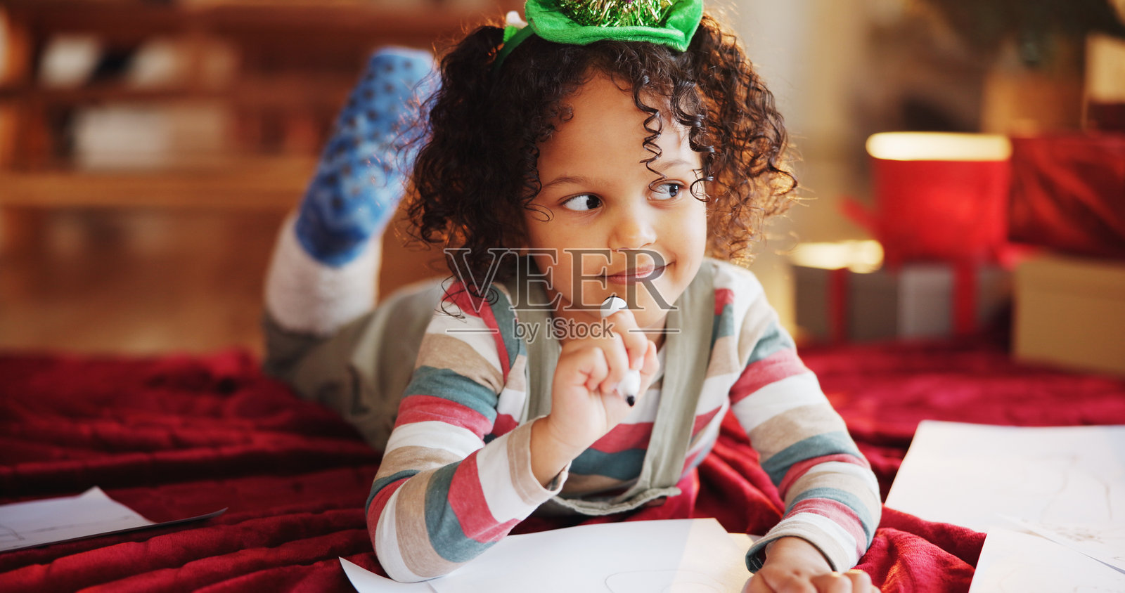 圣诞节,孩子与纸张一起思考和写愿望清单,感受节日的魔力、圣诞的欢愉和庆祝。给圣诞老人写信,冬季假期的创意,女孩在家中为礼物、假期或创意而构思。照片摄影图片