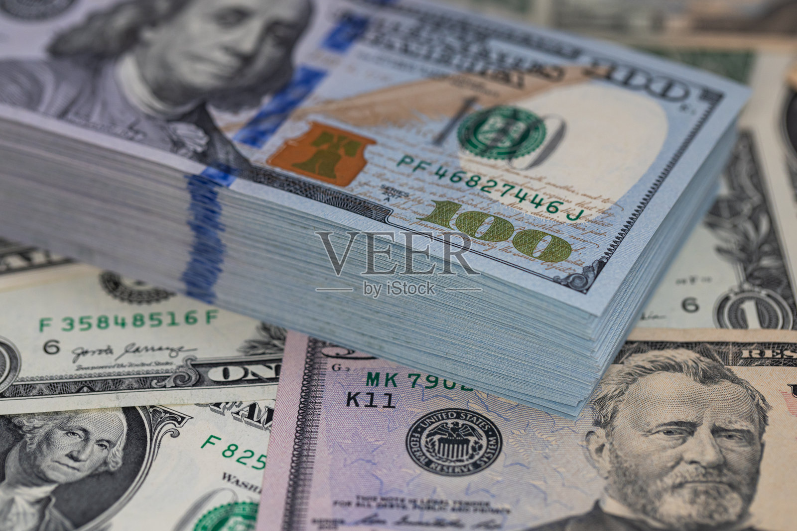 一堆100美元的钞票在美元背景上照片摄影图片