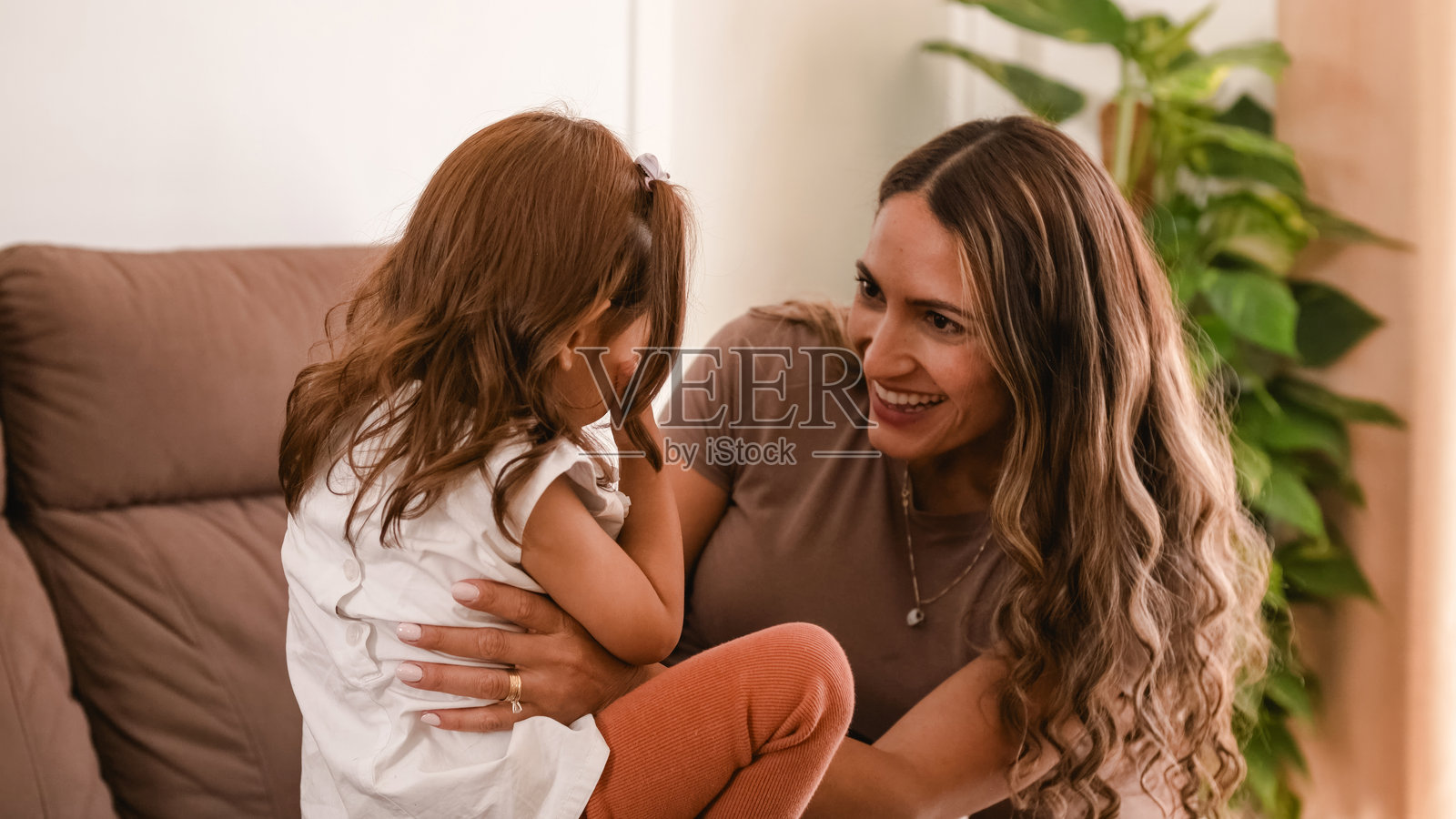 快乐的母亲和女儿在家里玩捉迷藏游戏照片摄影图片